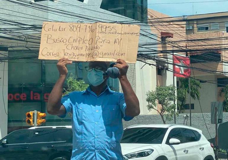Hombre sale a la calle a pedir empleo como chofer con un cartón en mano 