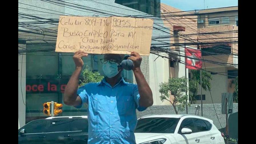 Hombre sale a la calle a pedir empleo como chofer con un cartón en mano 
