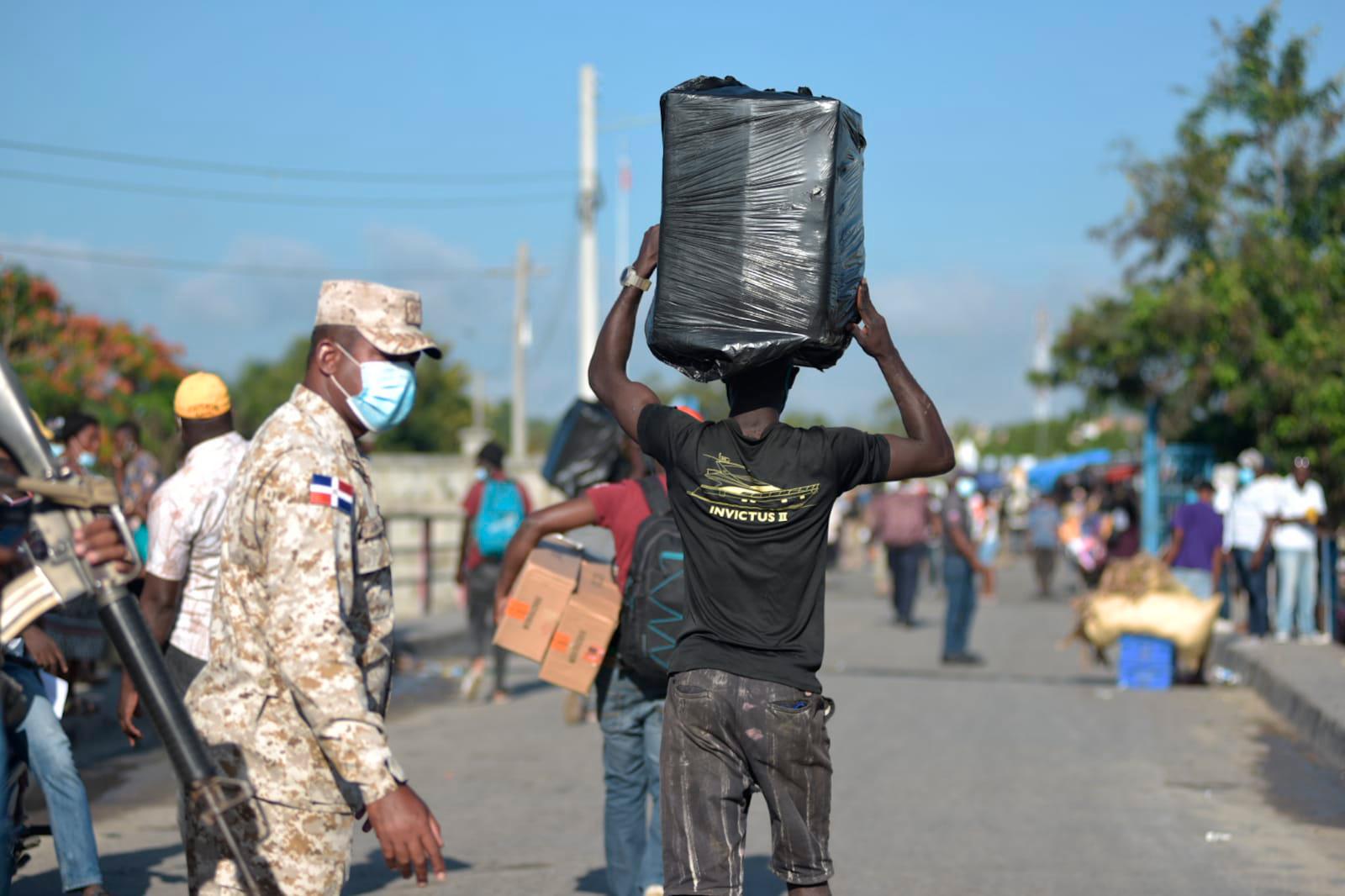 Personas cargan con productos para ser comercializados en la frontera domínico-haitiana, en Dajabón, República Dominicana.