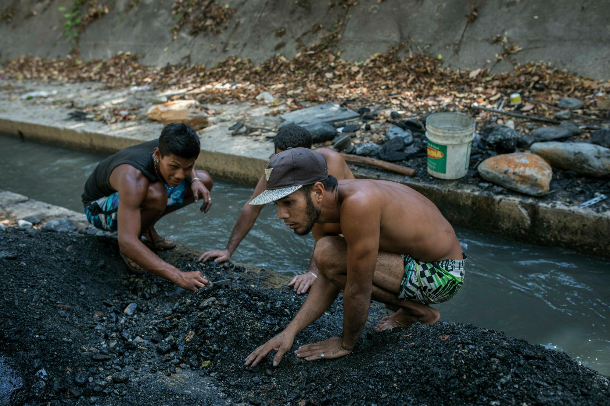 Los hombres trabajan en el contaminado río Guaire en busca de oro y cualquier cosa de valor para vender, en Caracas, Venezuela. en Caracas, Venezuela, lunes, 6 de mayo de 2019. 