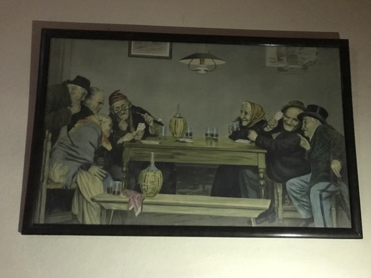 El mural que presenta un grupo de siete ancianos sobre una mesa en la que comparten vasos de vino, enfrentados en juego de cartas.