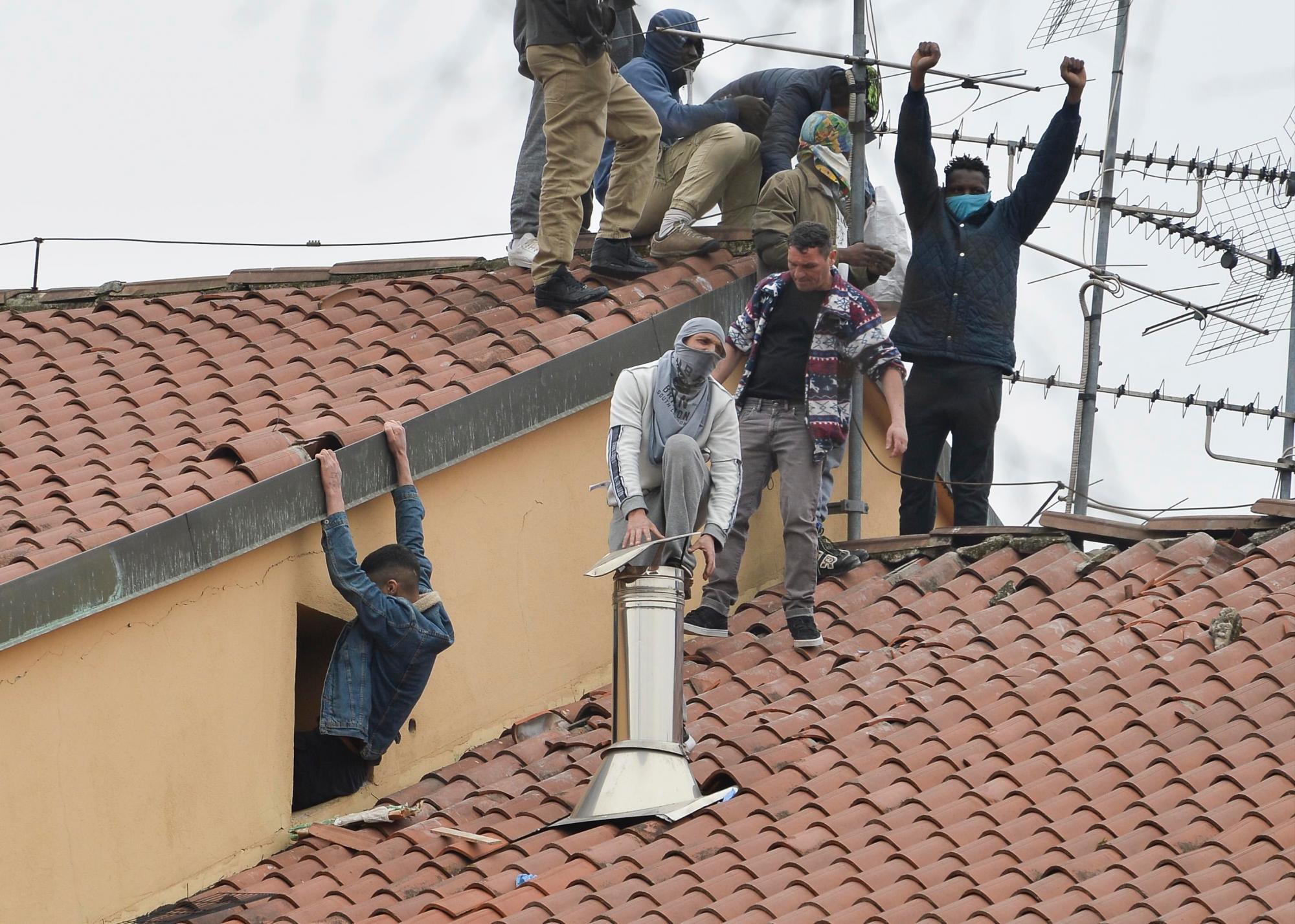 Varios reclusos de la prisión de San Vittore en Milán saltan sobre el tejado del centro penitenciario en protesta contra las novedosas restricciones del Gobierno para contener la expansión del coronavirus COVID-19, este lunes, en Italia.