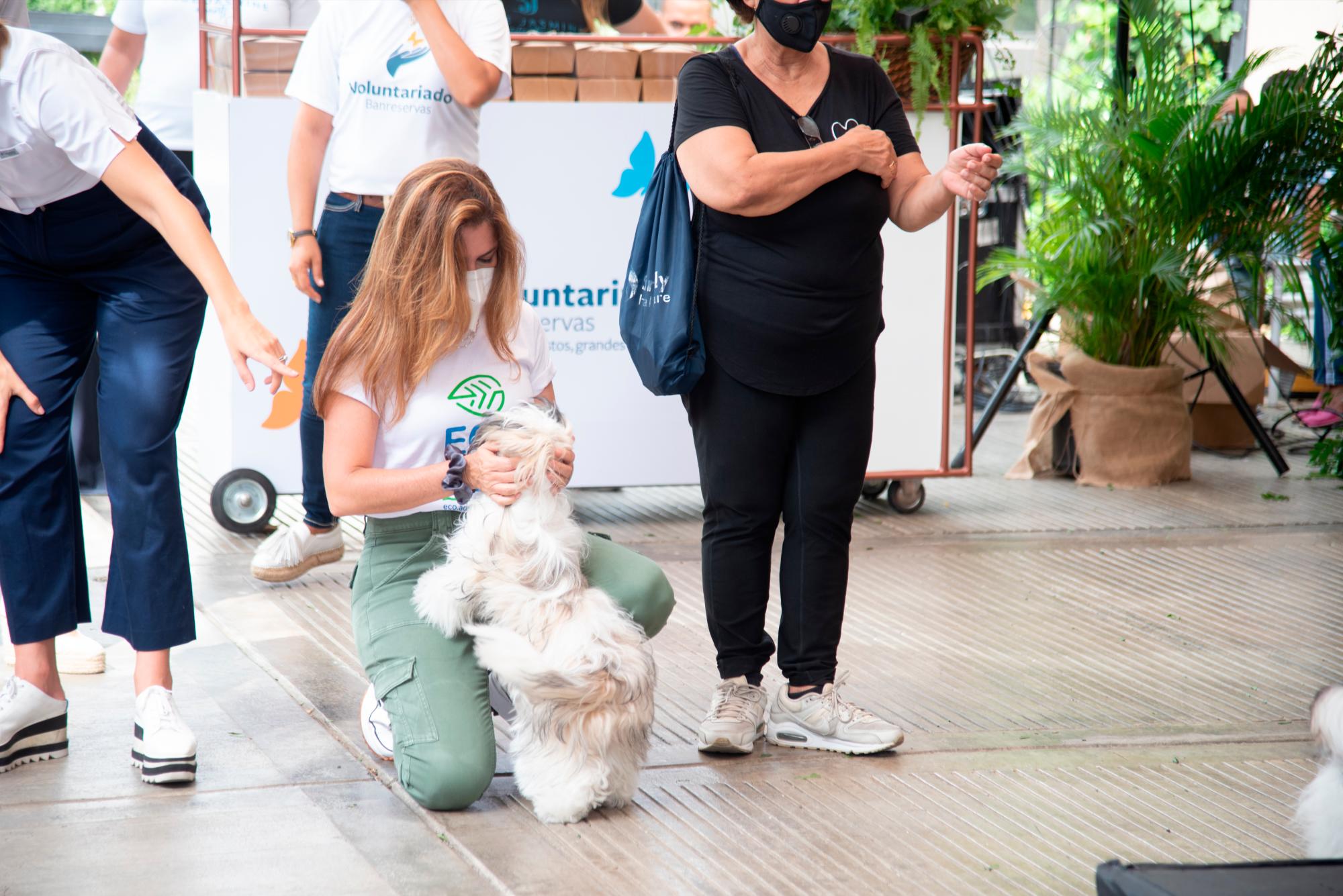 La alcaldesa juega con un perro, luego de la actividad. 