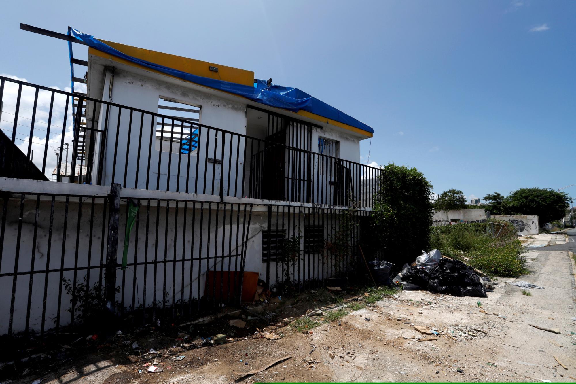 Fotografía este jueves de una casa con toldo azul sobre el techo destrozado debido al paso del huracán María hace tres años en San Juan, (Puerto Rico). (EFE/Thais Llorca)