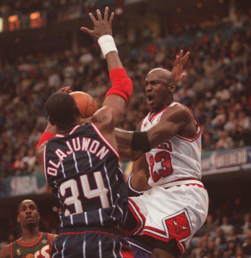 Olajuwon impide que Michael Jordan llegue al aro.