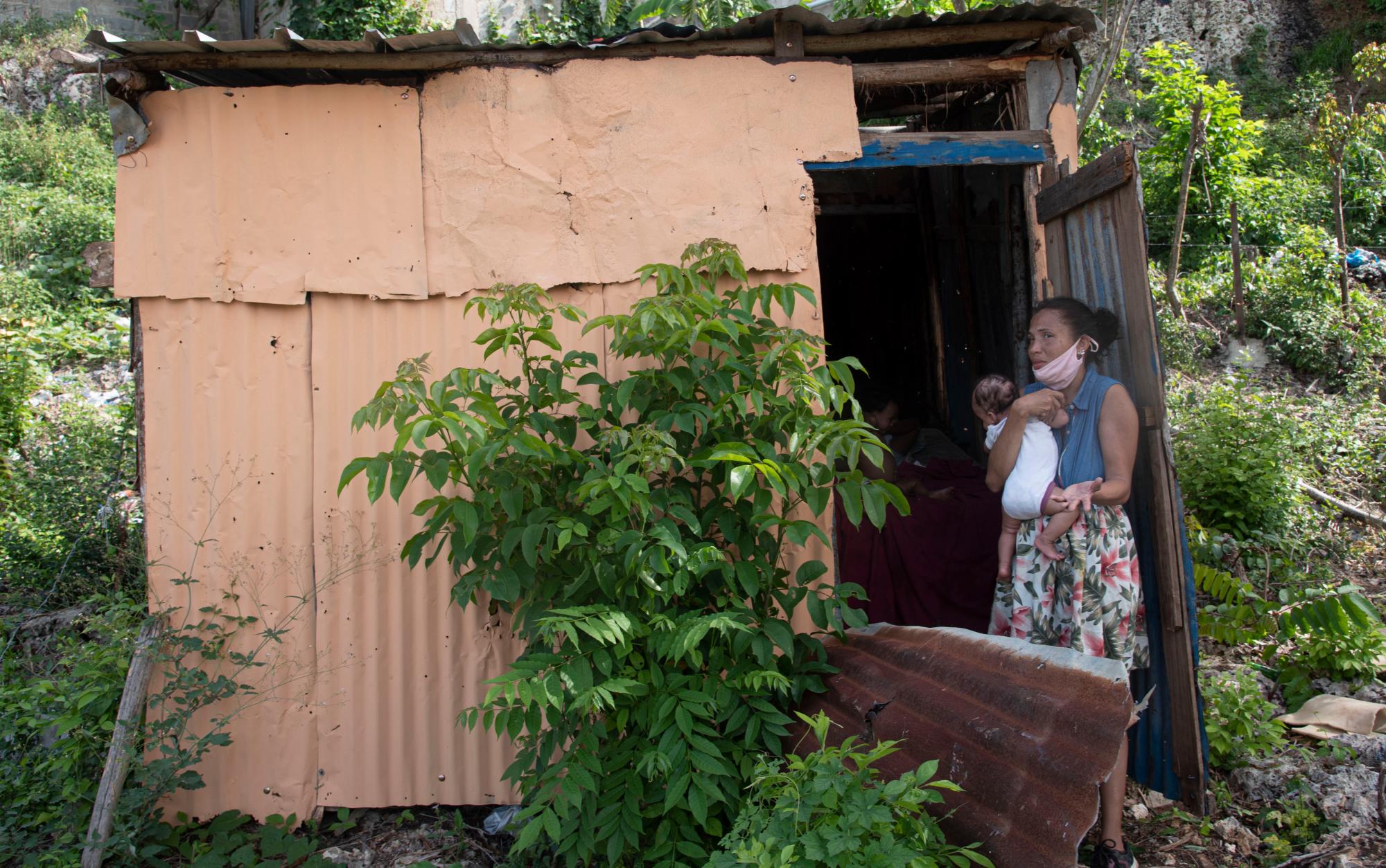 Beatriz de la Rosa, carga a su hija de tres meses, su casucha fue derribada por las autoridades.