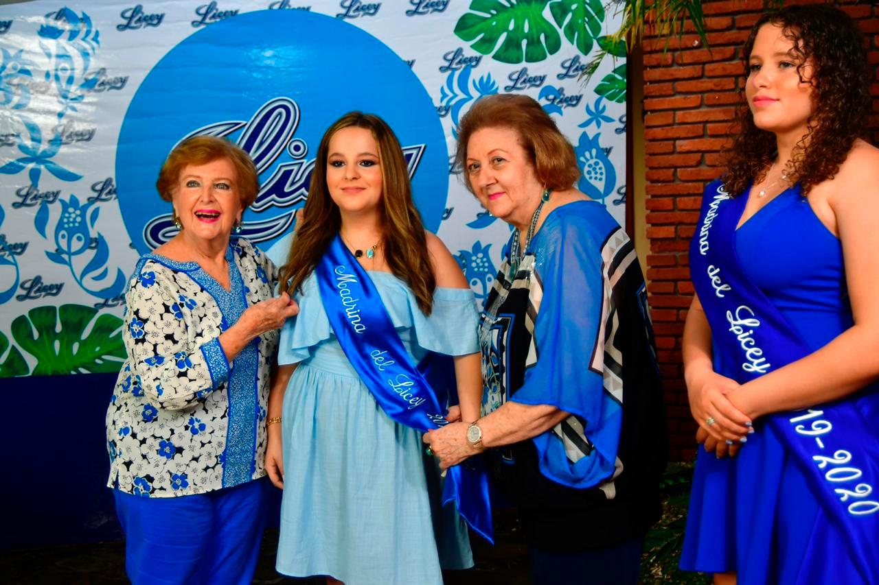 La presidente de la Rama Femenina del Licey, Mercedes Elmúdesi de Fernández, impone la banda a su nieta Adriana Fernández Pou, la nueva Madrina del Licey, junto a Matilde Dargam, vicepresidenta de la Rama y la madrina saliente Montserrat Alsina.