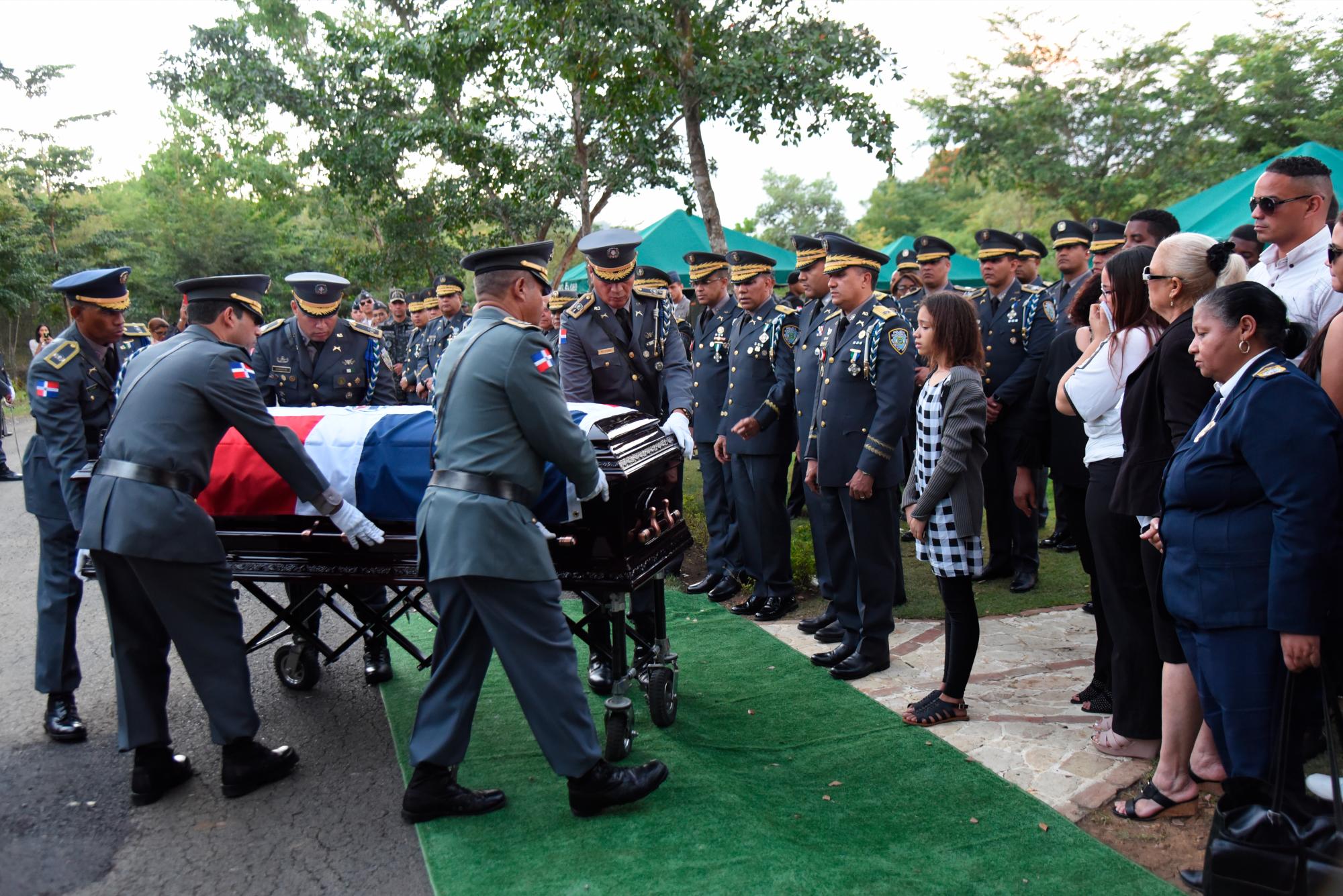 Agentes de la Policía, llevan el féretro.  