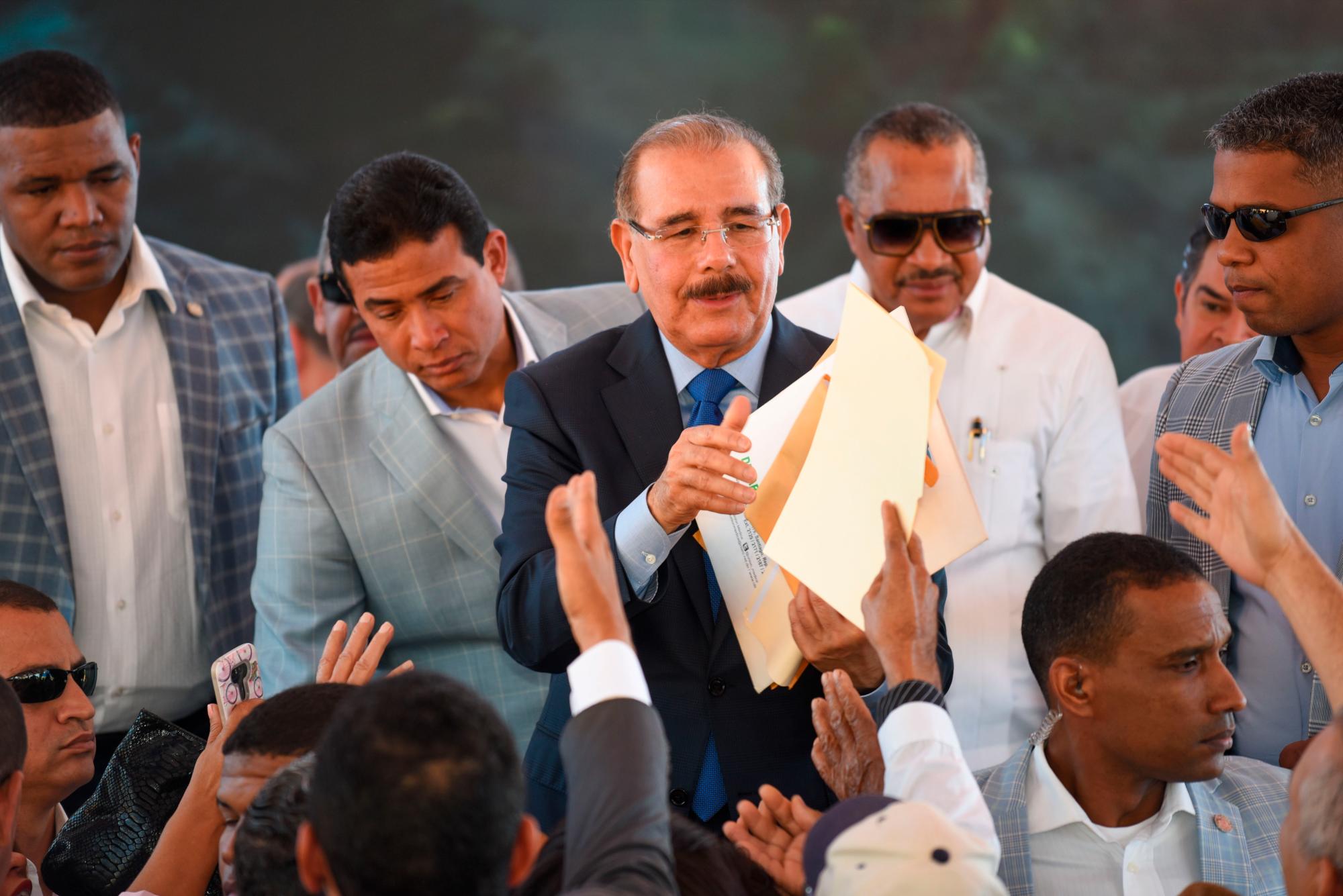 El presidente Danilo Medina mientras recibe documentos de las personas que asistieron al evento.