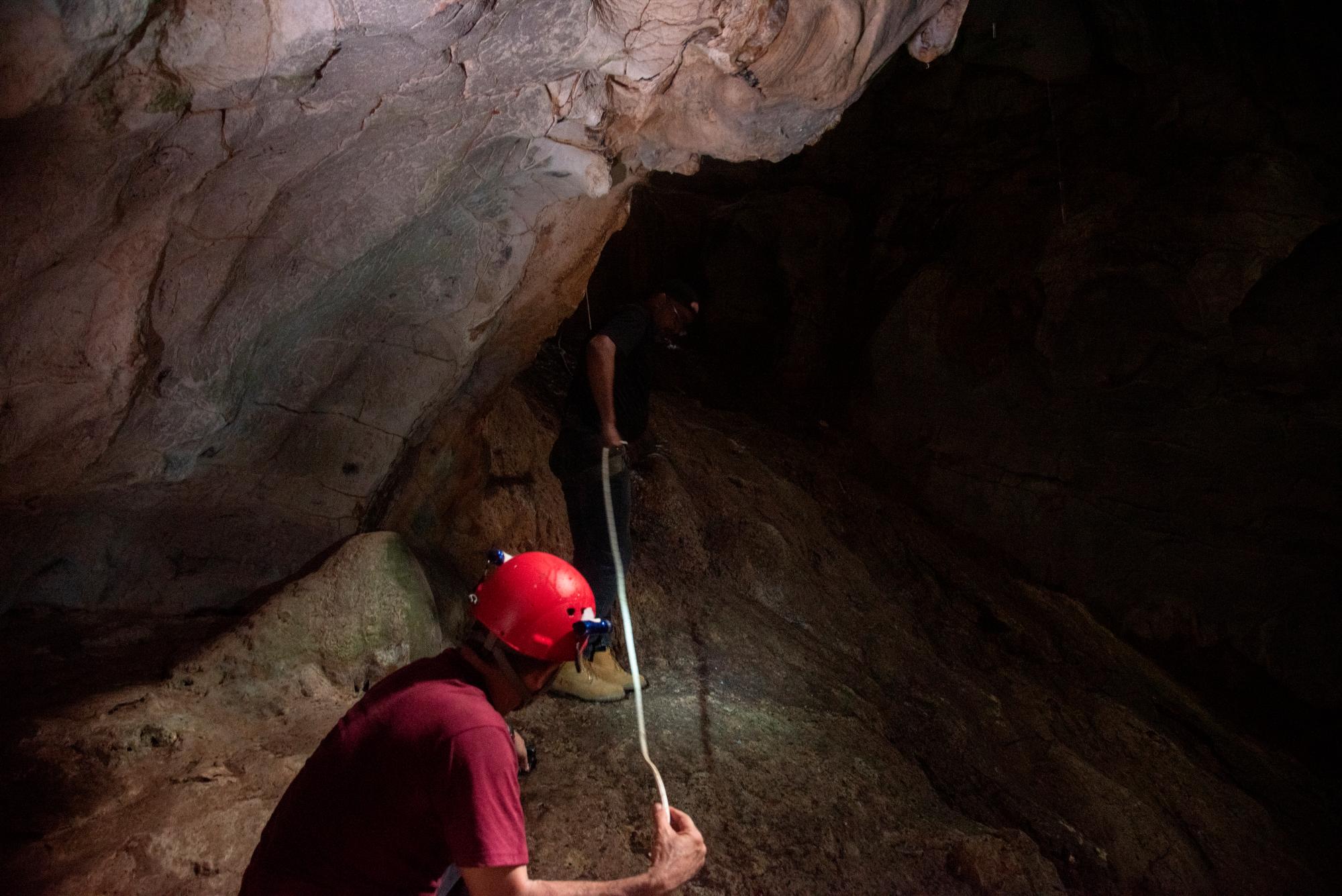 Manuel Grullón, presidente de la Sociedad Astronómica Dominicana, durante su descenso a la base de la cueva, asistido por el arqueólogo  y espeleólogo dominicano Domingo Abreu.