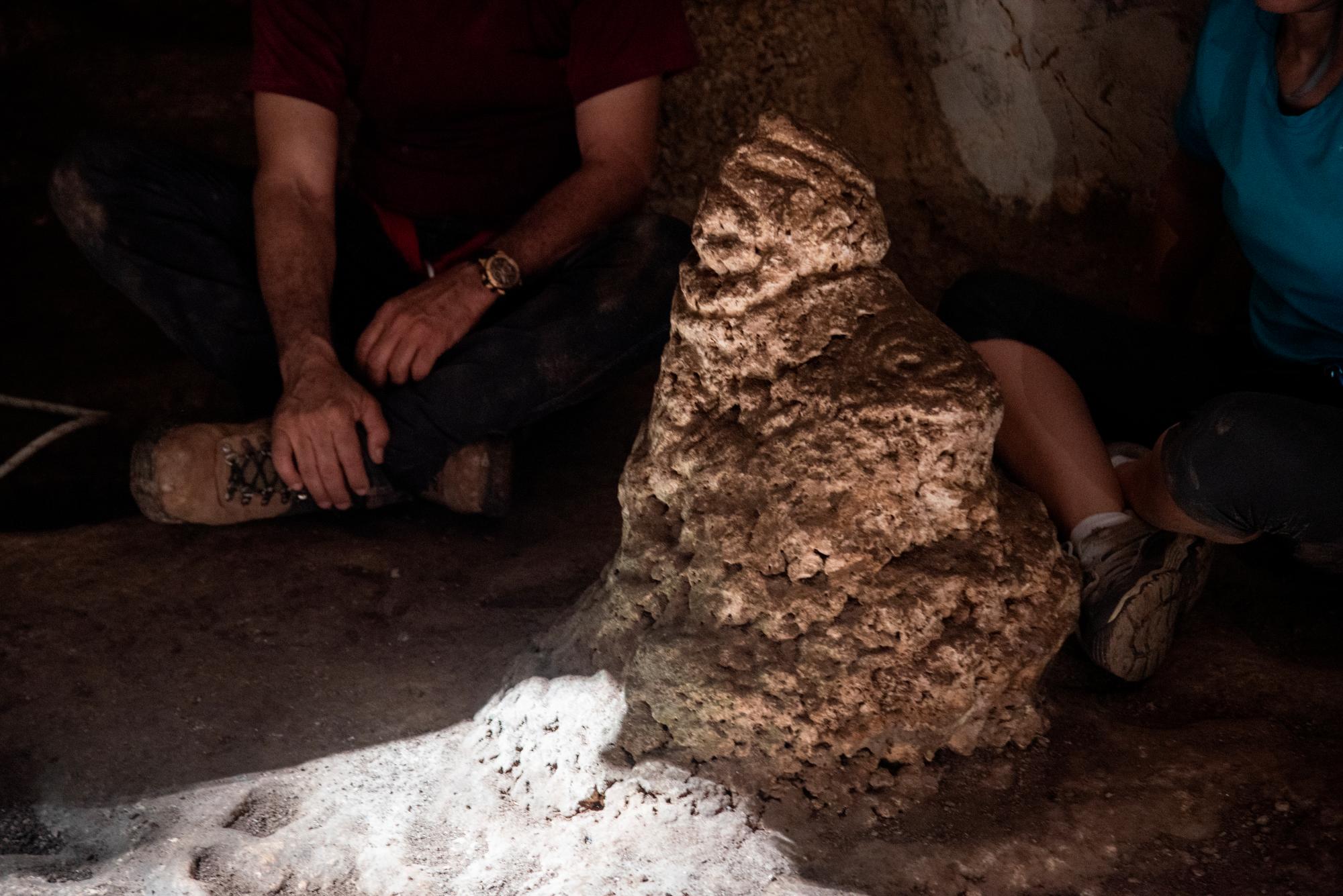 Detalle de la estalagmita donde se encuentran tallados Boinayel (derecha, mirando hacia arriba) y Márohu (izquierda, mirando de frente) justo cuando la luz solar toca su base.