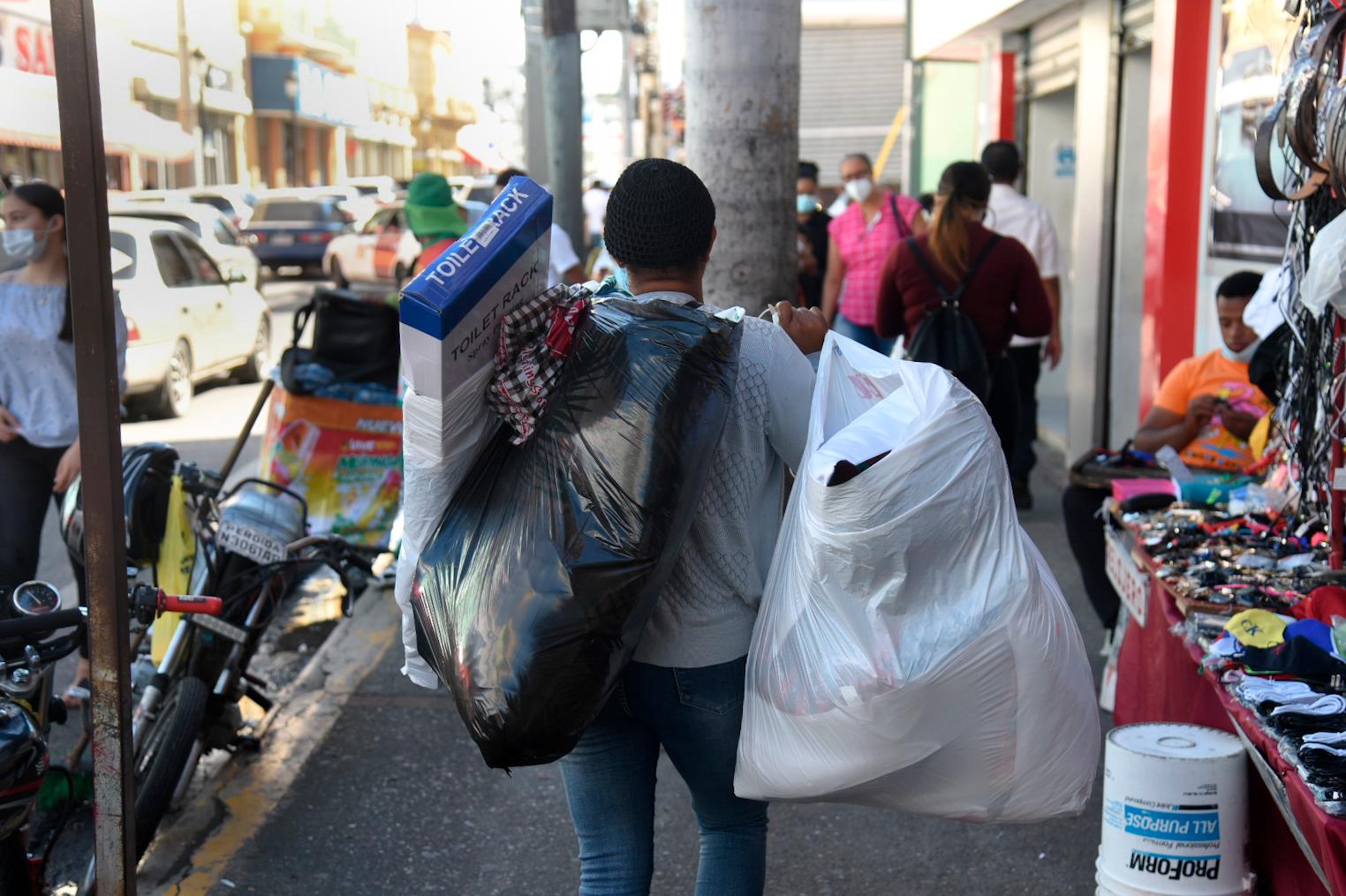 Una señora carga con fundas llenas de artículos adquiridos durante el viernes negro. 