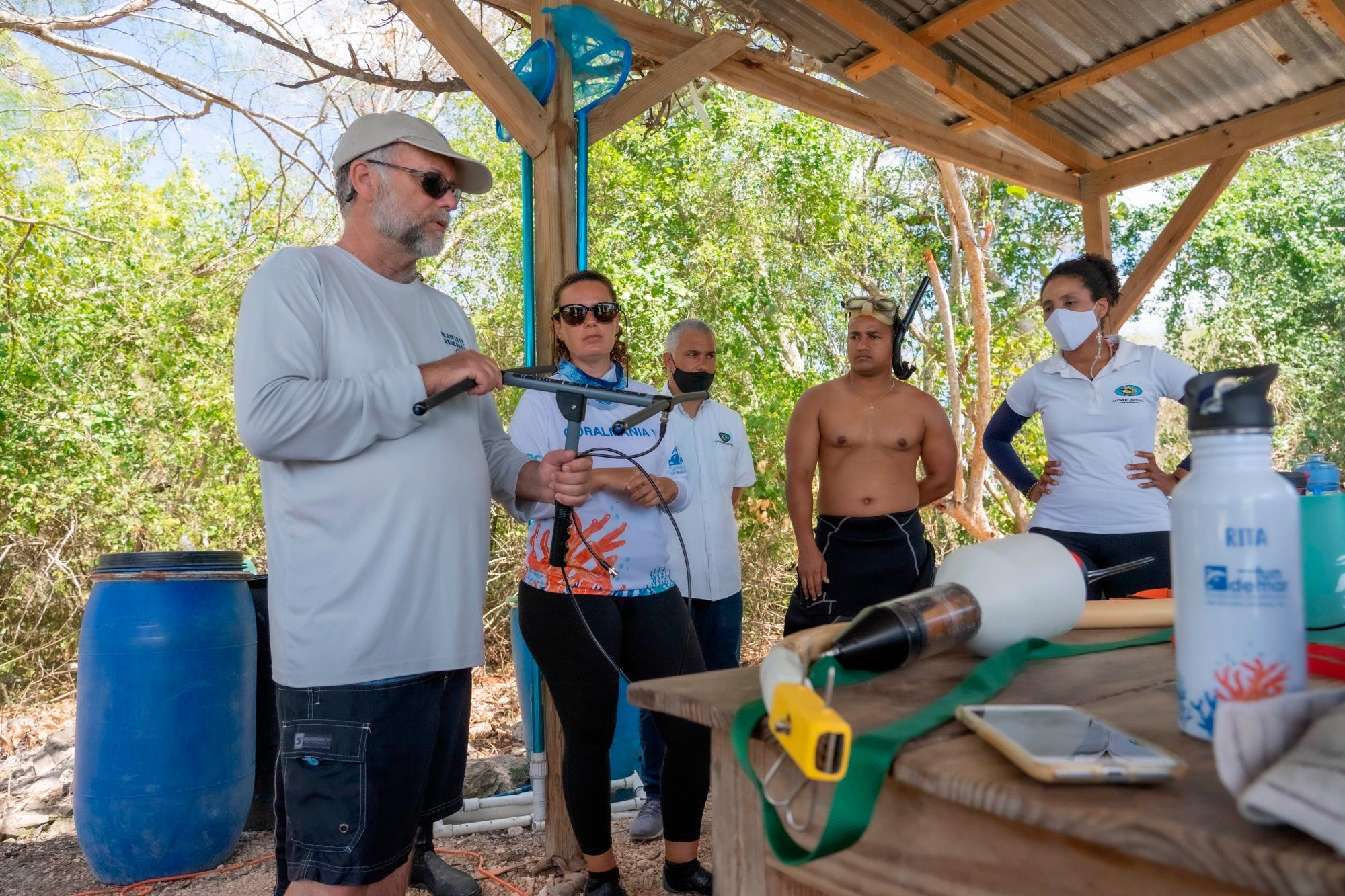 El Dr. James Powell muestra uno de los rastreadores a Nina Lisenko, Rita Sellares y José Ramón Reyes. 