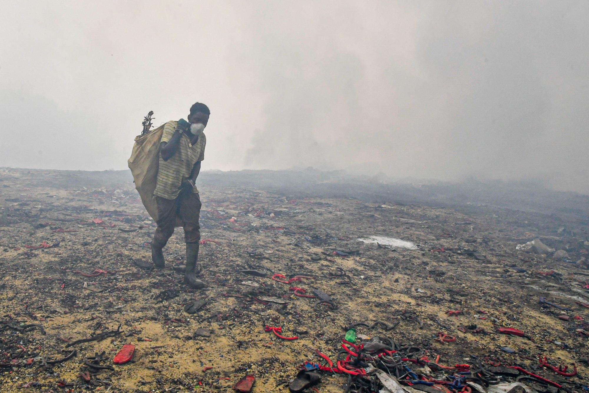 Un “Buzo” camina en el vertedero de Haina en busca de cualquier metal, muchas personas desafían a diario las llamas, el humo y las altas temperaturas que se originan en el lugar desde que se inició un incendio en la zona. 