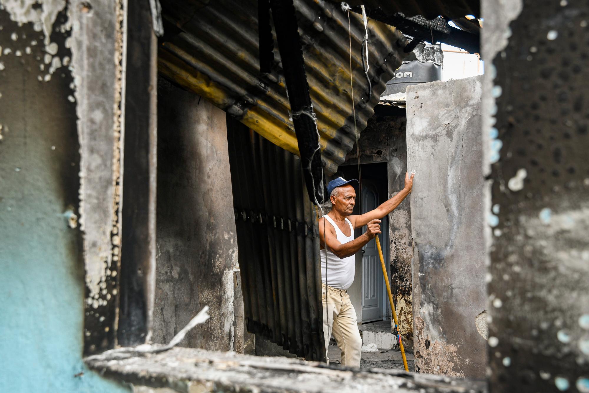 La gente recorre los escombros dejados por el incendio.