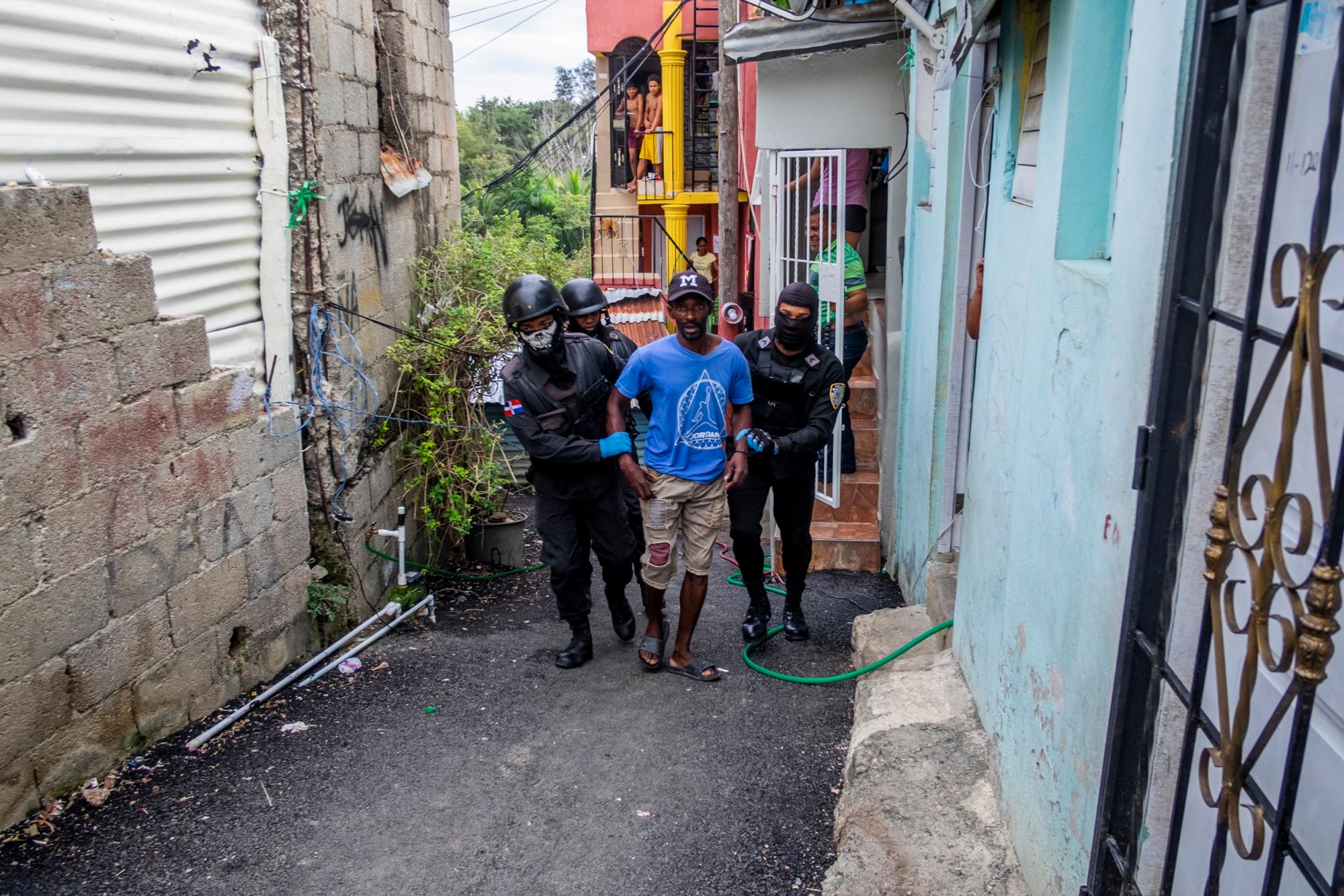 Efectivos de orden público realizando una redada en el sector Cristo Rey en Santo Domingo. reportes de la Policía Nacional muestran que desde el pasado viernes 20 hasta el día 25 de marzo, fueron arrestadas en total 9.856 personas. Se estableció que muchos de los arrestados eran reincidentes.