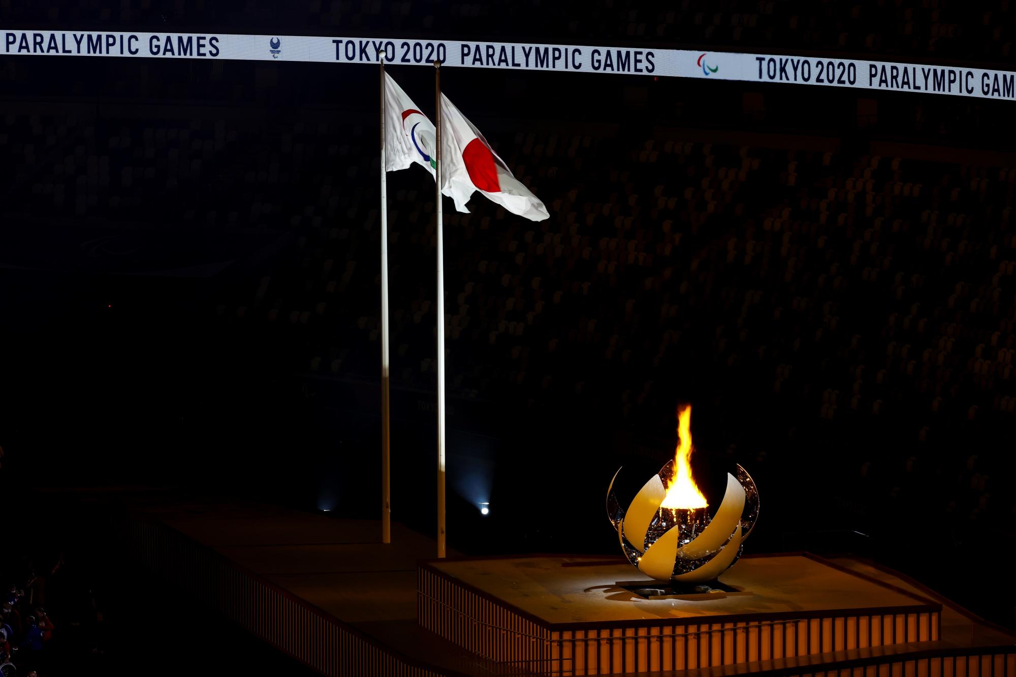 TOKIO, 24/08/2021.- Las banderas de Japón y del Comité Paralímpico ondean junto al pebetero en la ceremonia de inauguración de los Juegos Paralímpicos en el estadio Olímpico de Tokio (Japón). EFE/ Jaime de Diego (CPE)/SÓLO USO EDITORIAL/SÓLO DISPONIBLE PARA ILUSTRAR LA NOTICIA QUE ACOMPAÑA (CRÉDITO OBLIGATORIO) Michelle Alonso y Ricardo Ten, abanderados, encabezan el desfile de los integrantes de la expedición española en el estadio Olímpico de Tokio