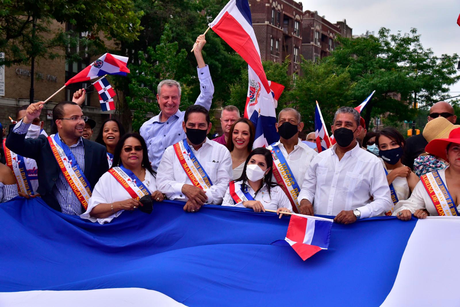 Autoridades dominicanas y de la ciudad de Nueva York cargan la bandera dominicana mientras desfilan por la gran Parada Dominicana de El Bronx.