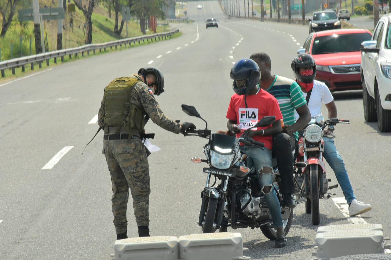 Un guardia registra a un motorista en la Autopista Duarte.