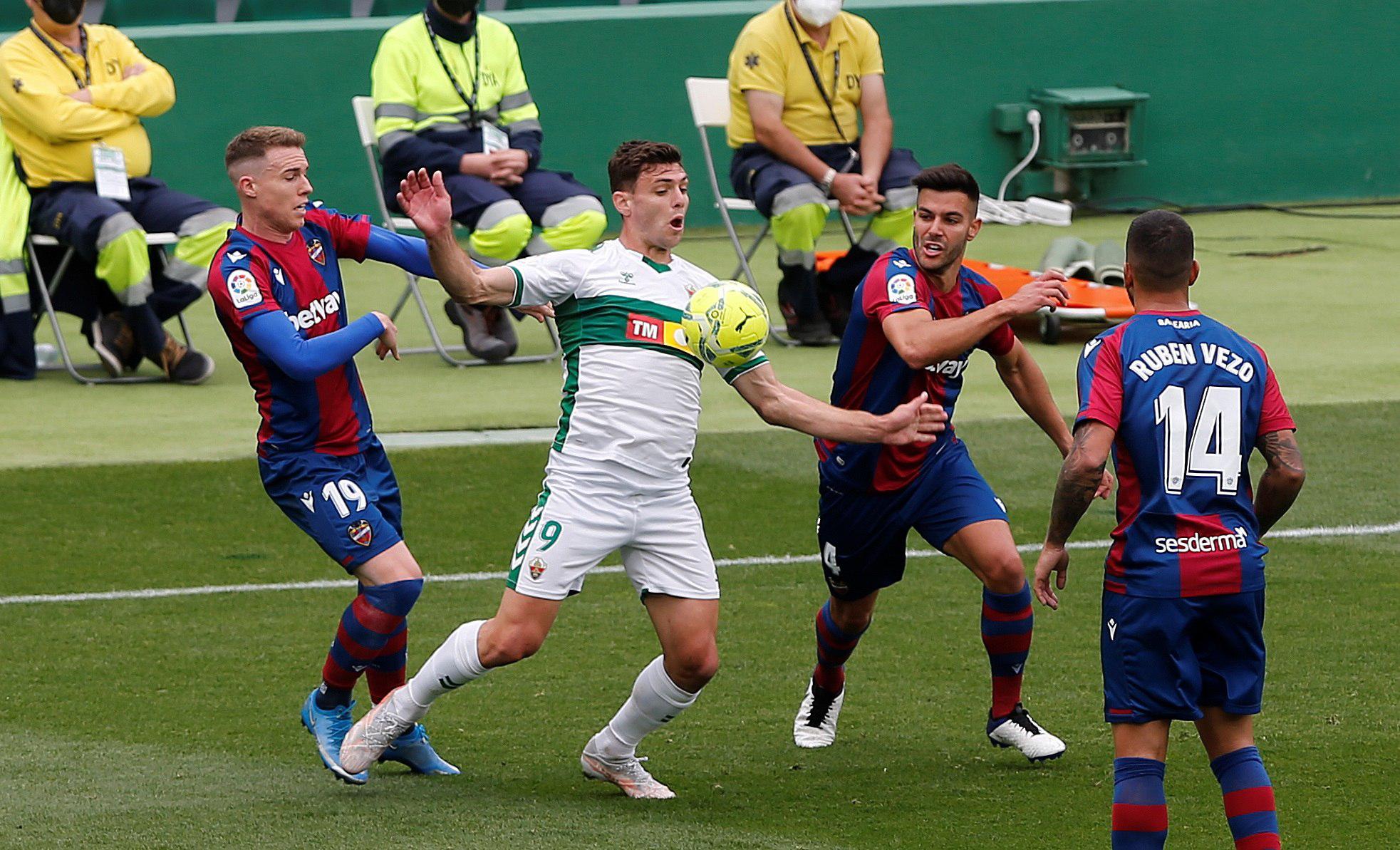 GRAF1390. ELCHE, 24/04/2021.- El delantero argentino del Elche, Lucas Boyé (2i), lucha por el balón con los jugadores del Levante Clerc (i) y Rober Pier durante el partido de la jornada 32 de LaLiga que disputaron ambos equipos este sábado en el estadio Martínez Valero de Elche. (EFE/Manuel Lorenzo)