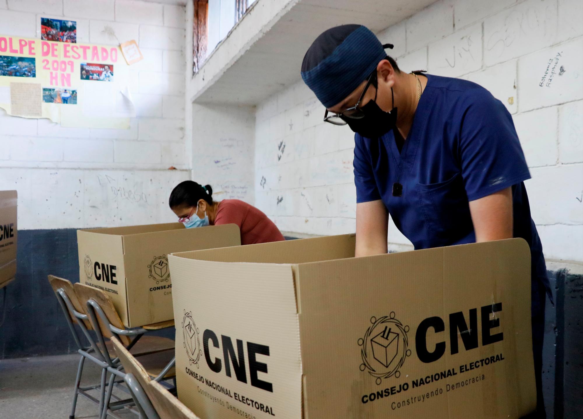 Hondureños sufragan durante las votaciones en las elecciones generales en el país hoy, domingo 28 de noviembre de 2021, con la presencia de observadores internacionales en las instalaciones del gimnasio del Instituto Central Vicente Cáceres en Tegucigalpa. 