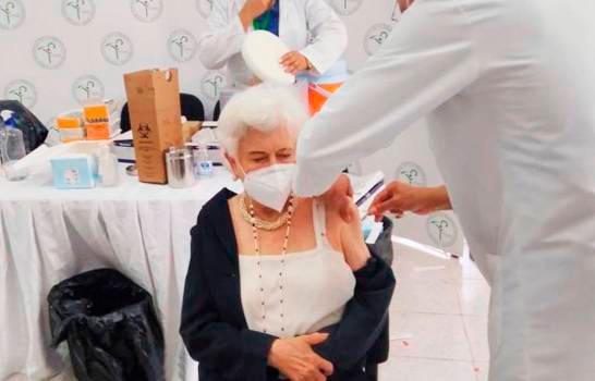 Milagros Ortiz Bosch recibiendo la primera dosis de la vacuna contra el COVID-19.