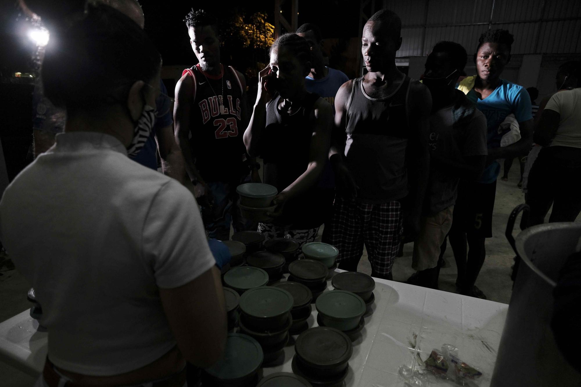 Familias haitianas reciben alimentos ayer, en un centro comunal en la zona de Palmar Norte, a 259 kilómetros de San José (Costa Rica). (EFE/ Jeffrey Arguedas)