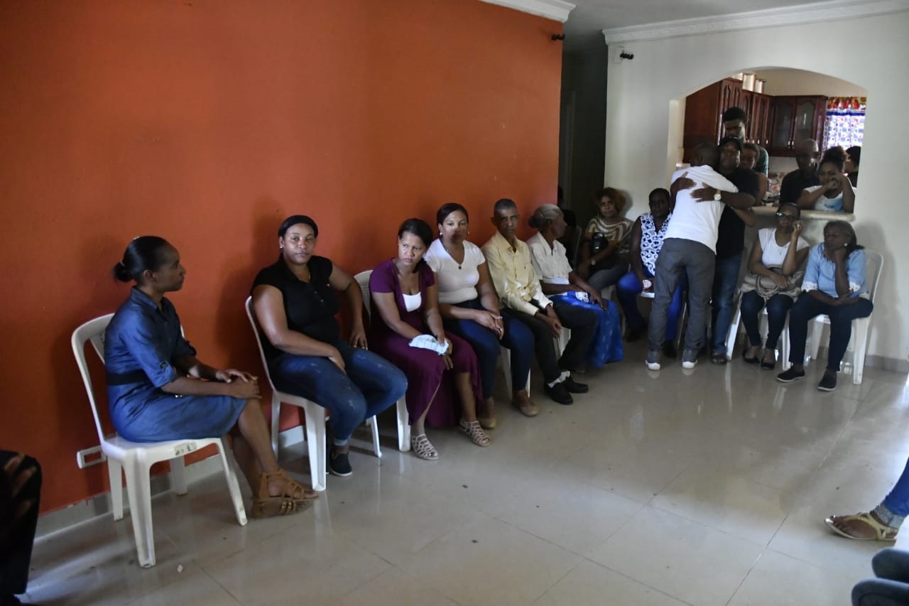 Parientes y conocidos de los dos hombres e igual número de mujeres encontrados muertos en una yipeta en la comunidad la Mojarra, en el municipio de Guerra, provincia de Santo Domingo.