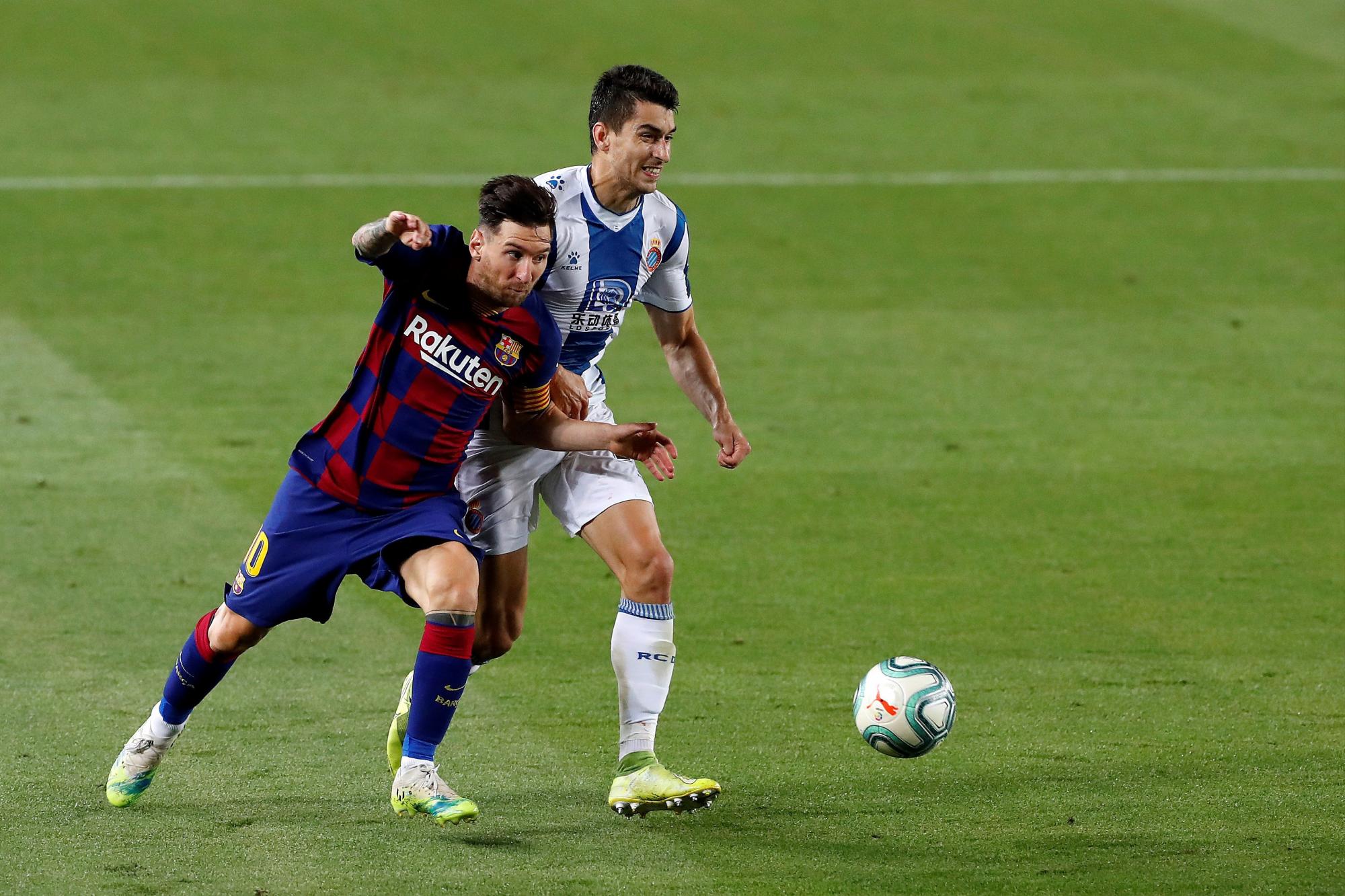 El delantero del FC Barcelona Leo Messi (i) trata de escapar de Dídac, del Espanyol, durante el partido de Liga en Primera División que disputan esta noche en el Camp Nou, en Barcelona. (EFE/Alberto Estévez)