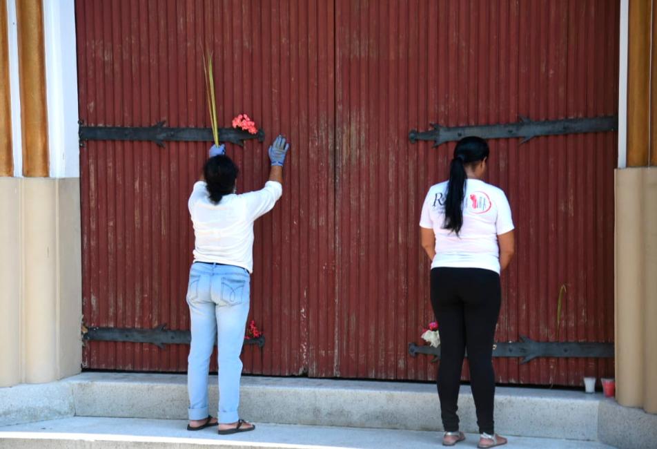 Dos mujeres creyentes rezan en la iglesia San José del sector Baracoa, Santiago.