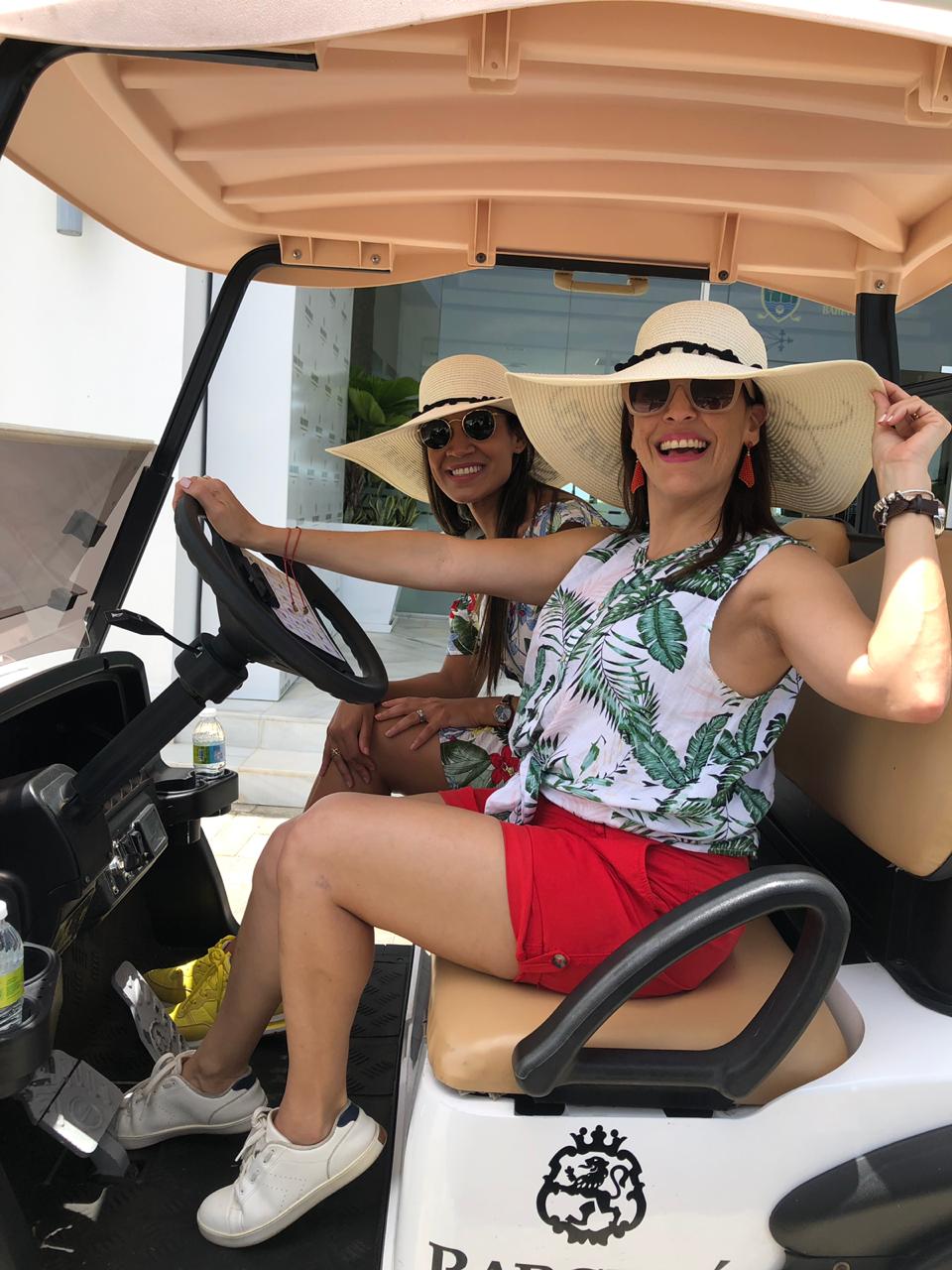 Keila Rodríguez y Onysela Valdez arrancan en su carrito de golf.