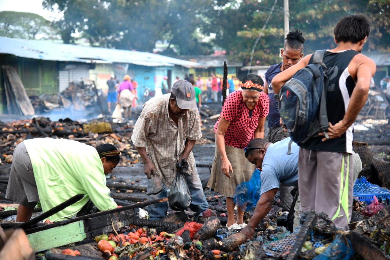 Los vendedores del mercado tratan de salvar algunas de sus mercancías tras el fuego que destruyó el mercado provisional de La Vega.