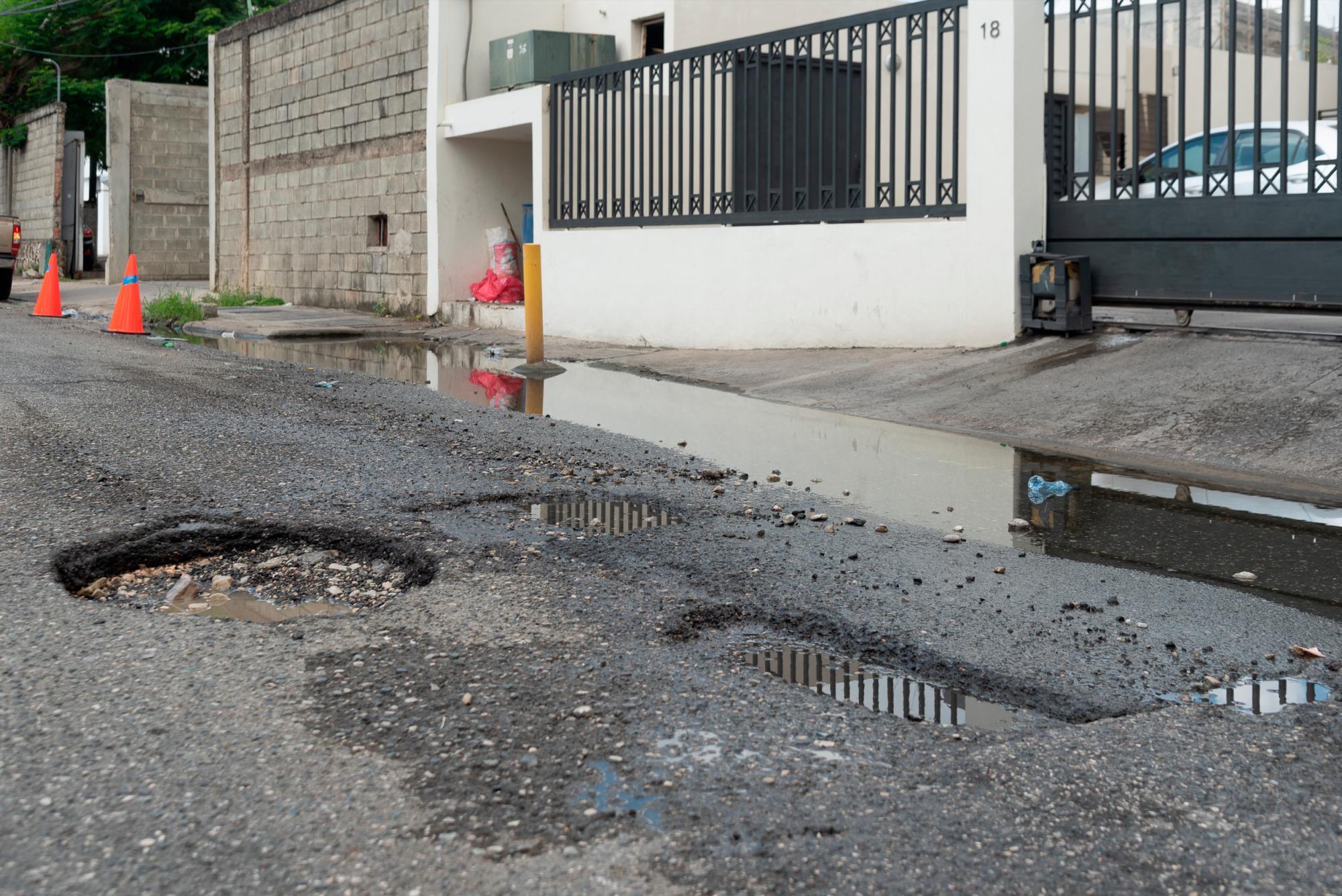La acumulación de agua ha causado deterioro de la calle.