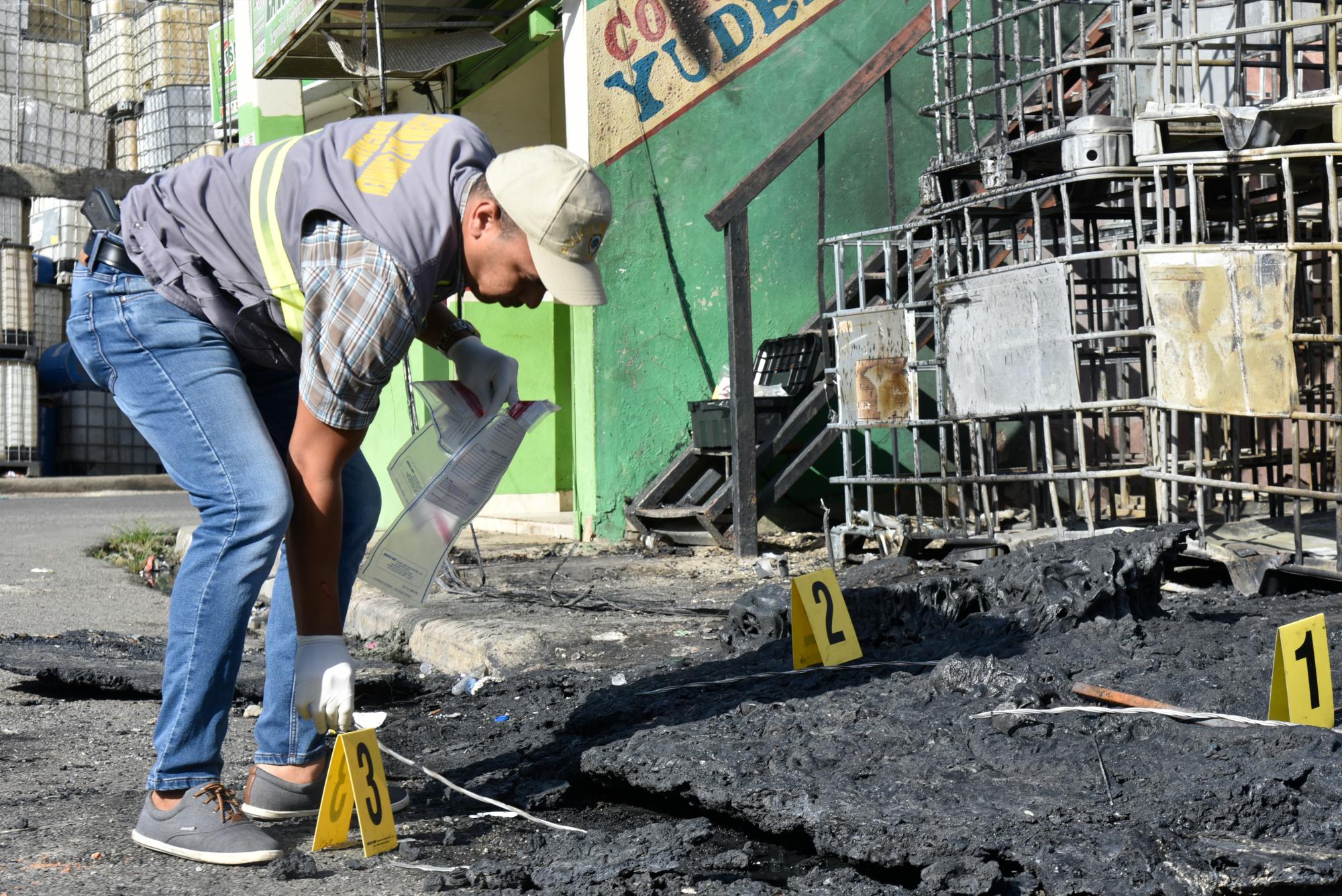 Un miembros del Dicrim recoge muestra de cables en el incendio.