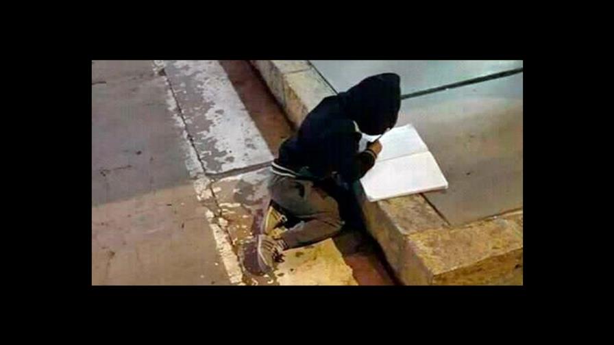Niño hace sus tareas en la calle mientras su madre trabaja