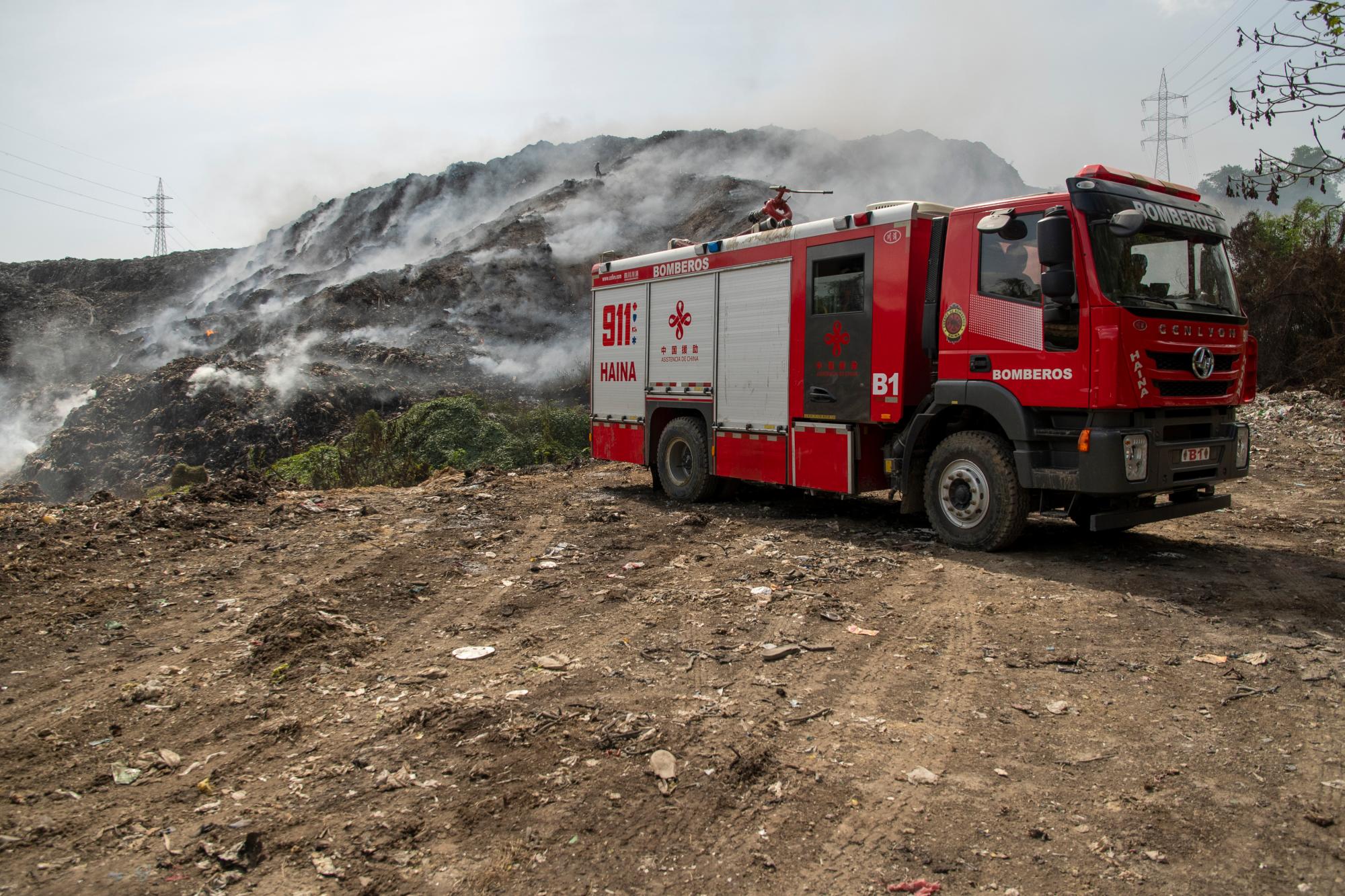 Un camión de bomberos es reabastecido constantemente en el vertedero. 