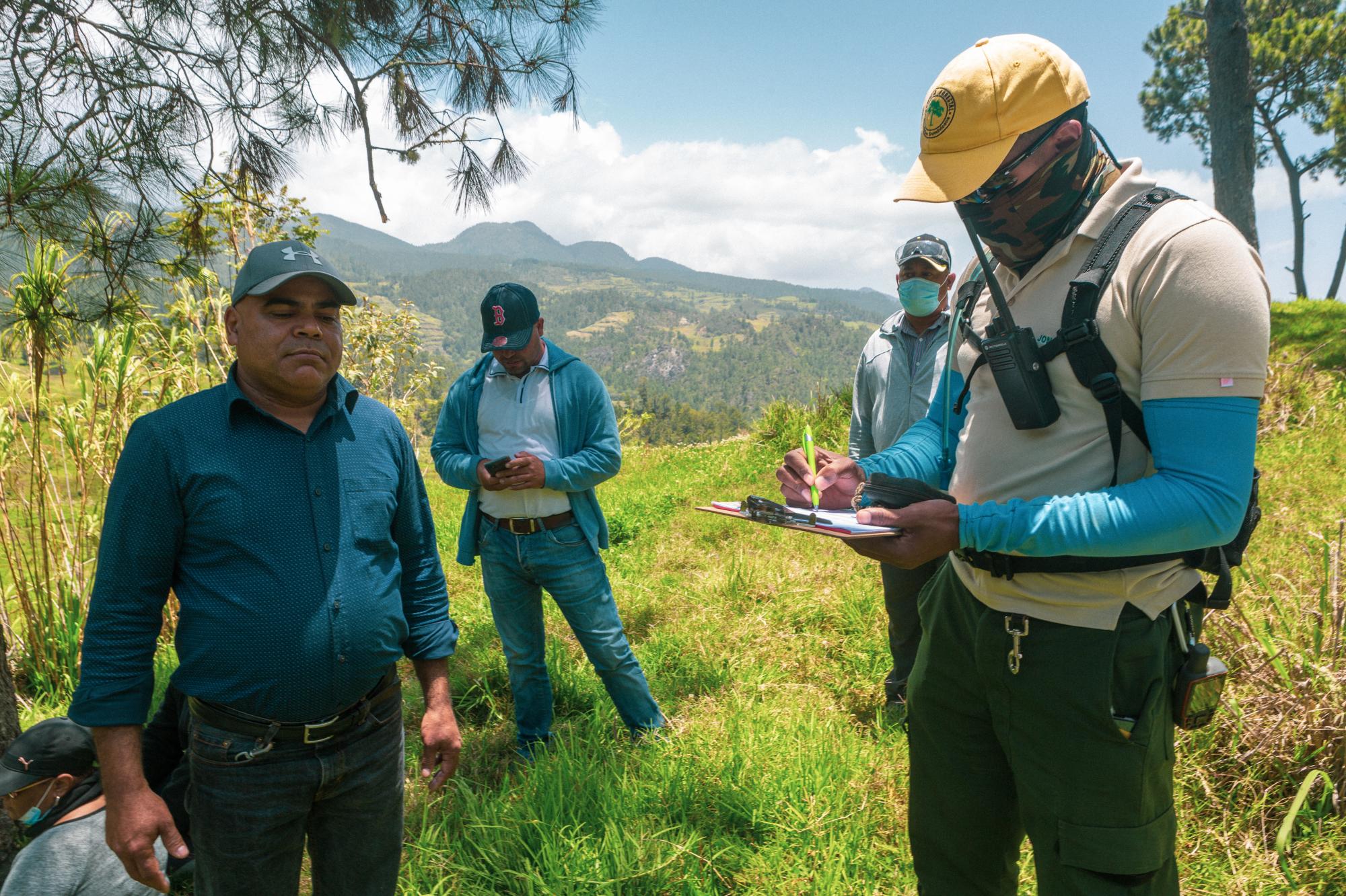 Gabriel Durán espera por las instrucciones del técnico de Medio Ambiente, mientras este llena el formulario con sus datos.