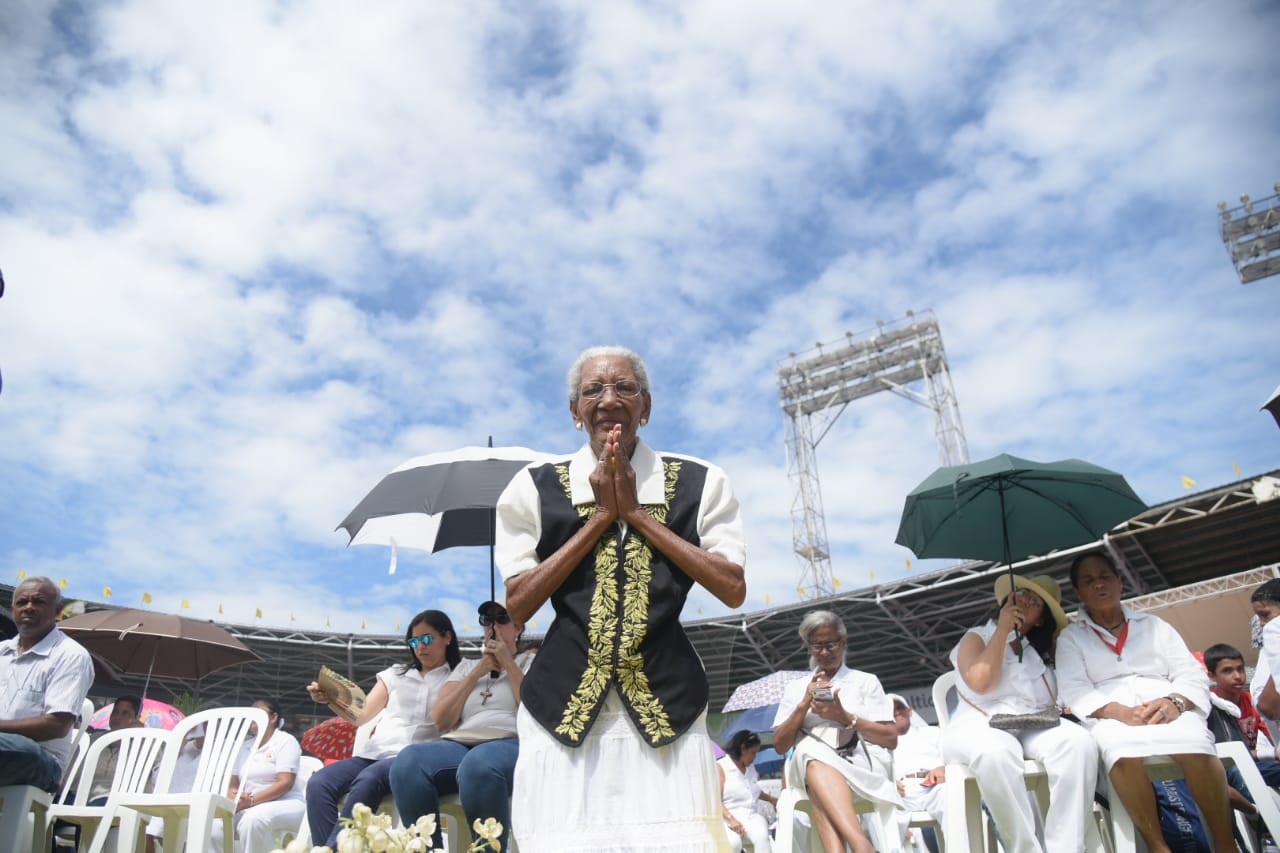 Una señora ora en la eucaristía en Santiago por el Día de Corpus Christi.