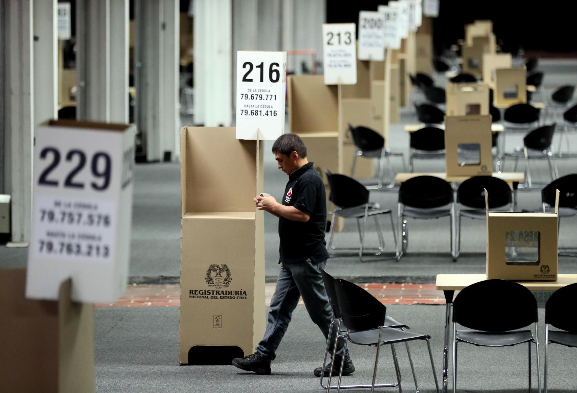 Un hombre camina entre las mesas de votación del colegio electoral que se instalaba este sábado en Corferias, en Bogotá. Corferias es centro electoral del país que recibe a más votantes.
