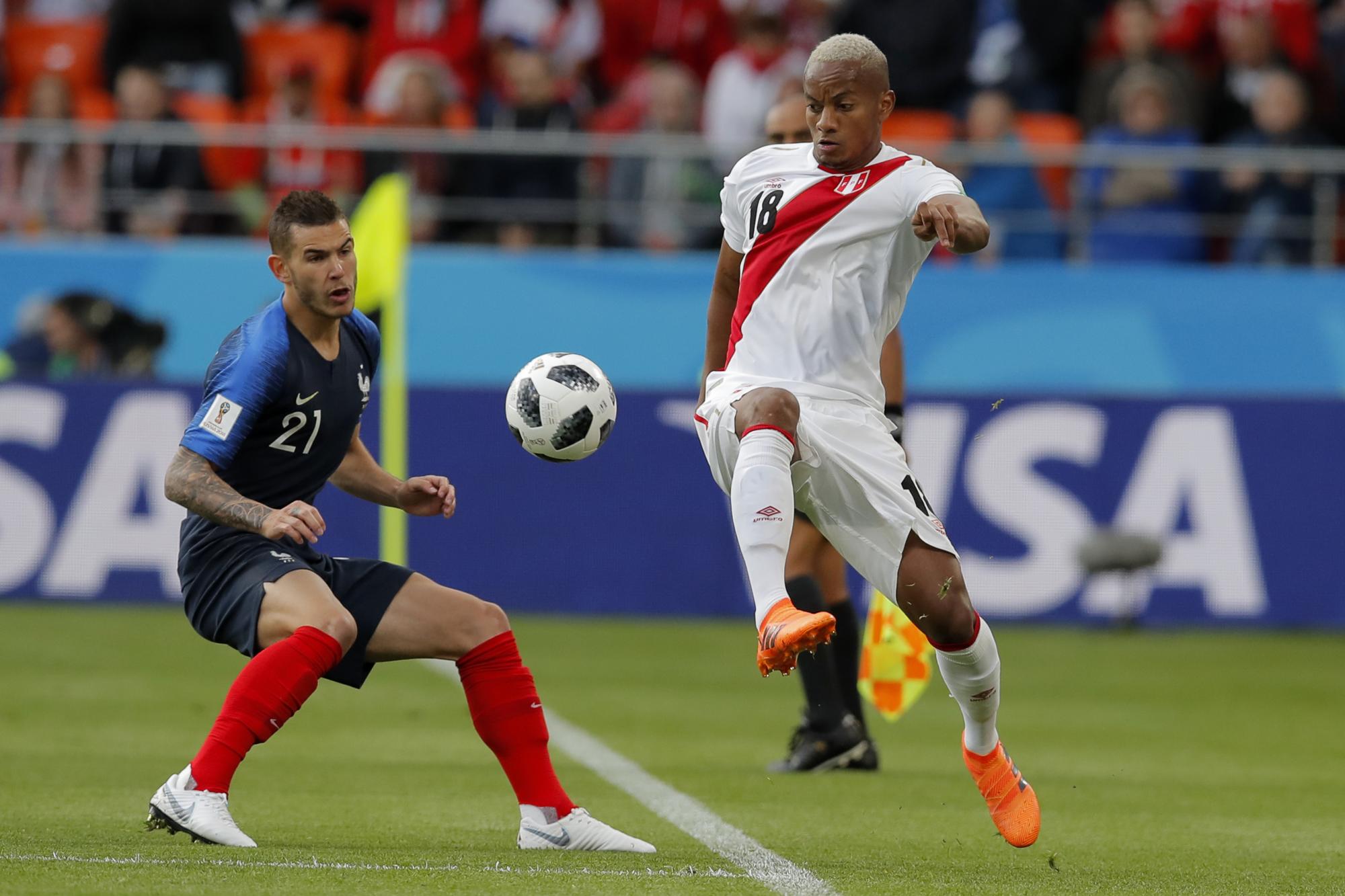 El peruano Andre Carrillo, izquierda, pasa por el balón al francés Lucas Hernández durante el partido del grupo C entre Francia y Perú en la Copa Mundial de fútbol 2018 en el Yekaterinburg Arena en Ekaterimburgo, Rusia, el jueves 21 de junio de 2018. 