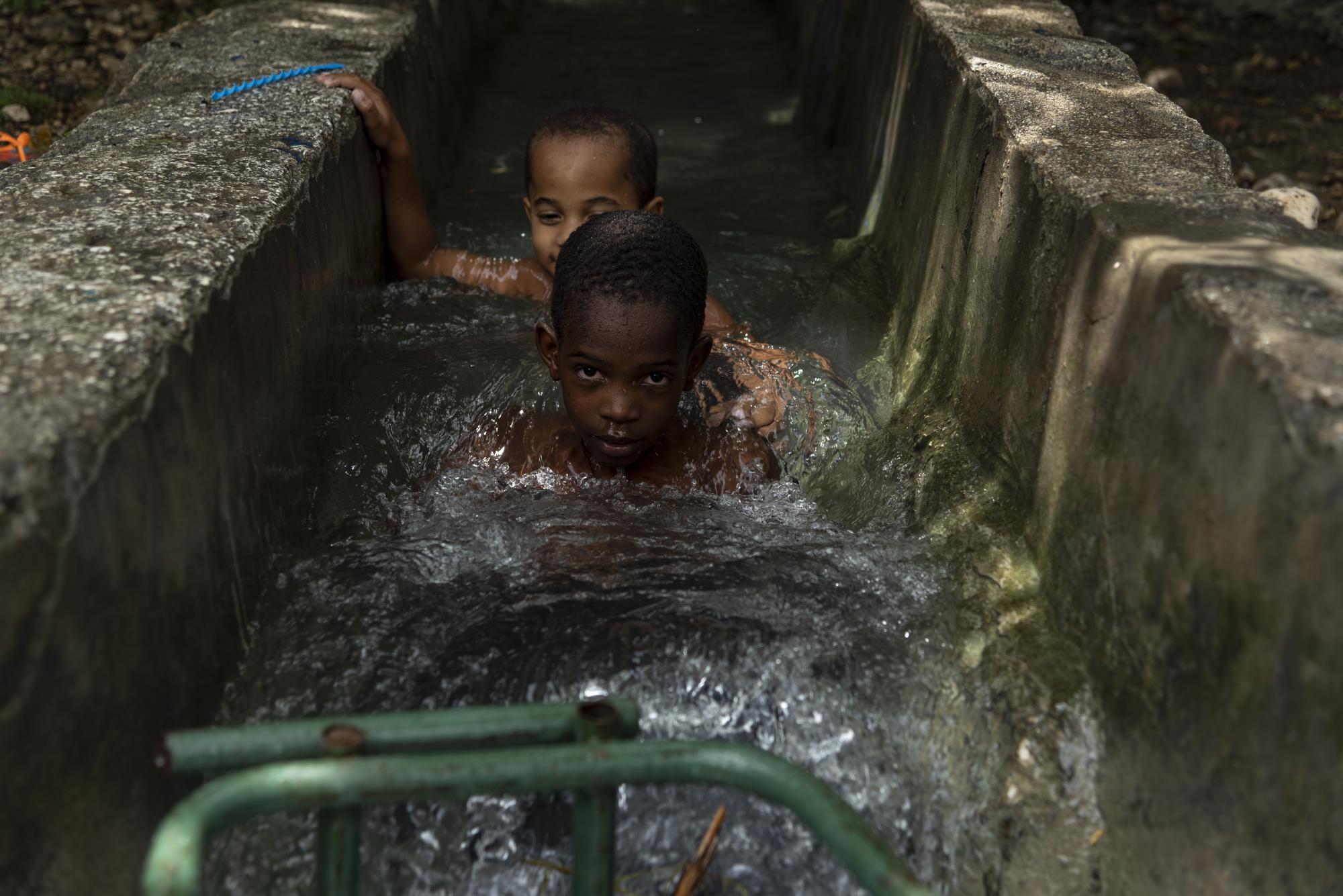 Los residentes de las comunidades utilizan el agua que baja de los canales para bañarse.
