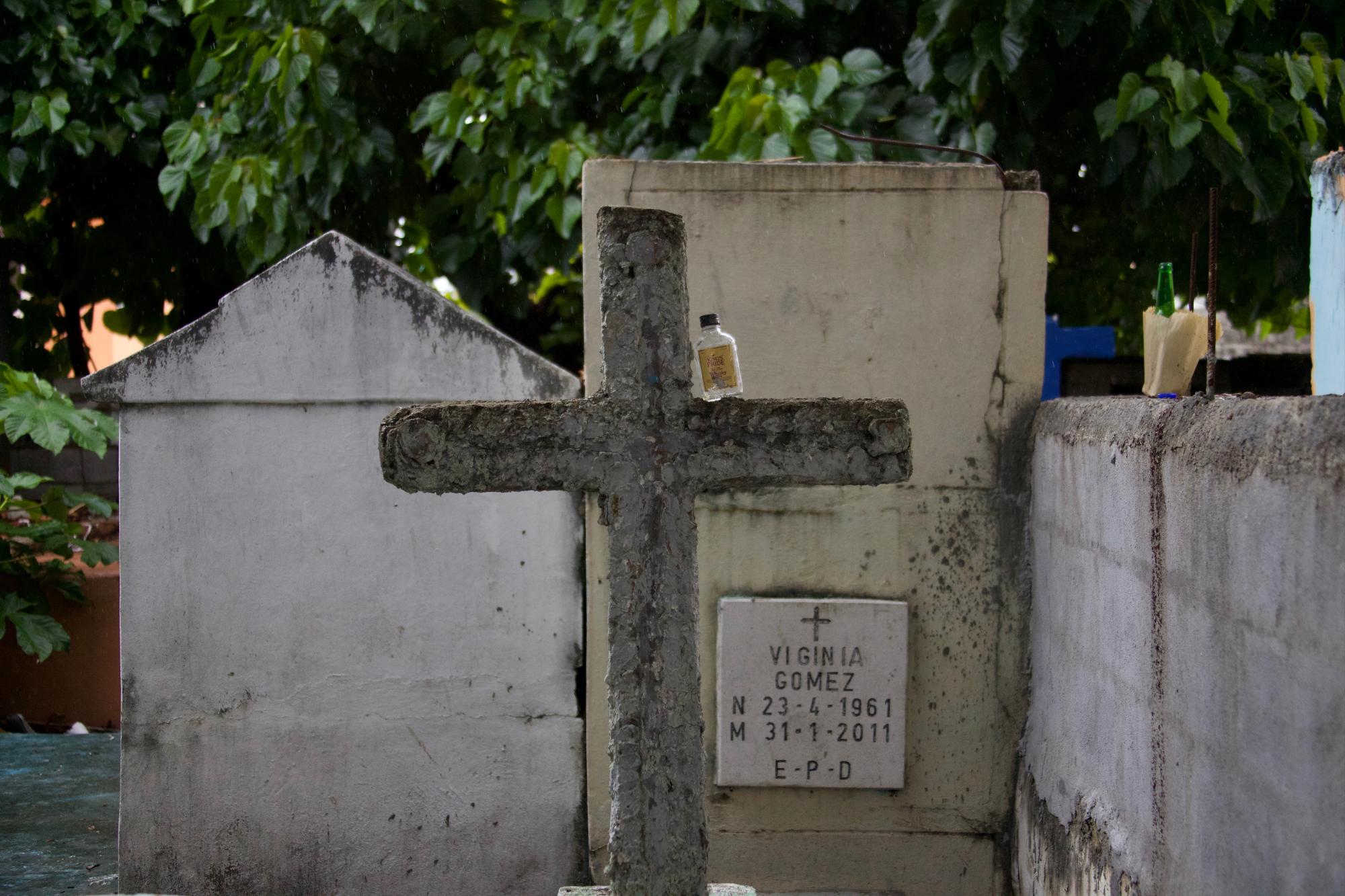 Una botella de ron ‘adorna’ una de las tumbas del camposanto. Al fondo a la derecha, una botella de cerveza.