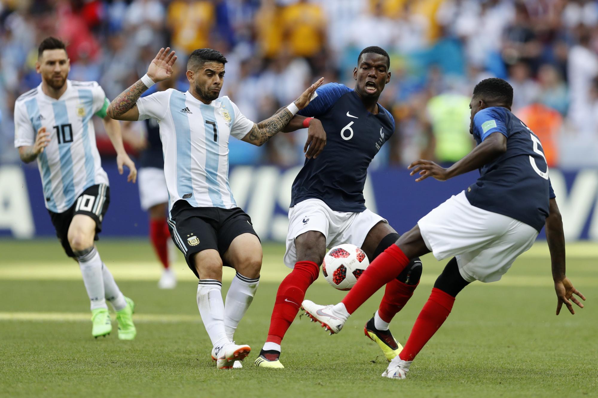 El argentino Ever Banega, izquierda, y el francés Paul Pogba, segundo derecho, desafío por el balón, además del argentino Lionel Messi, fondo izquierdo, y el francés Samuel Umtiti, justo durante el partido de octavos de final entre Francia y Argentina en el Mundial de fútbol 2018 en el Kazan Arena en Kazan, Rusia, el sábado 30 de junio de 2018.