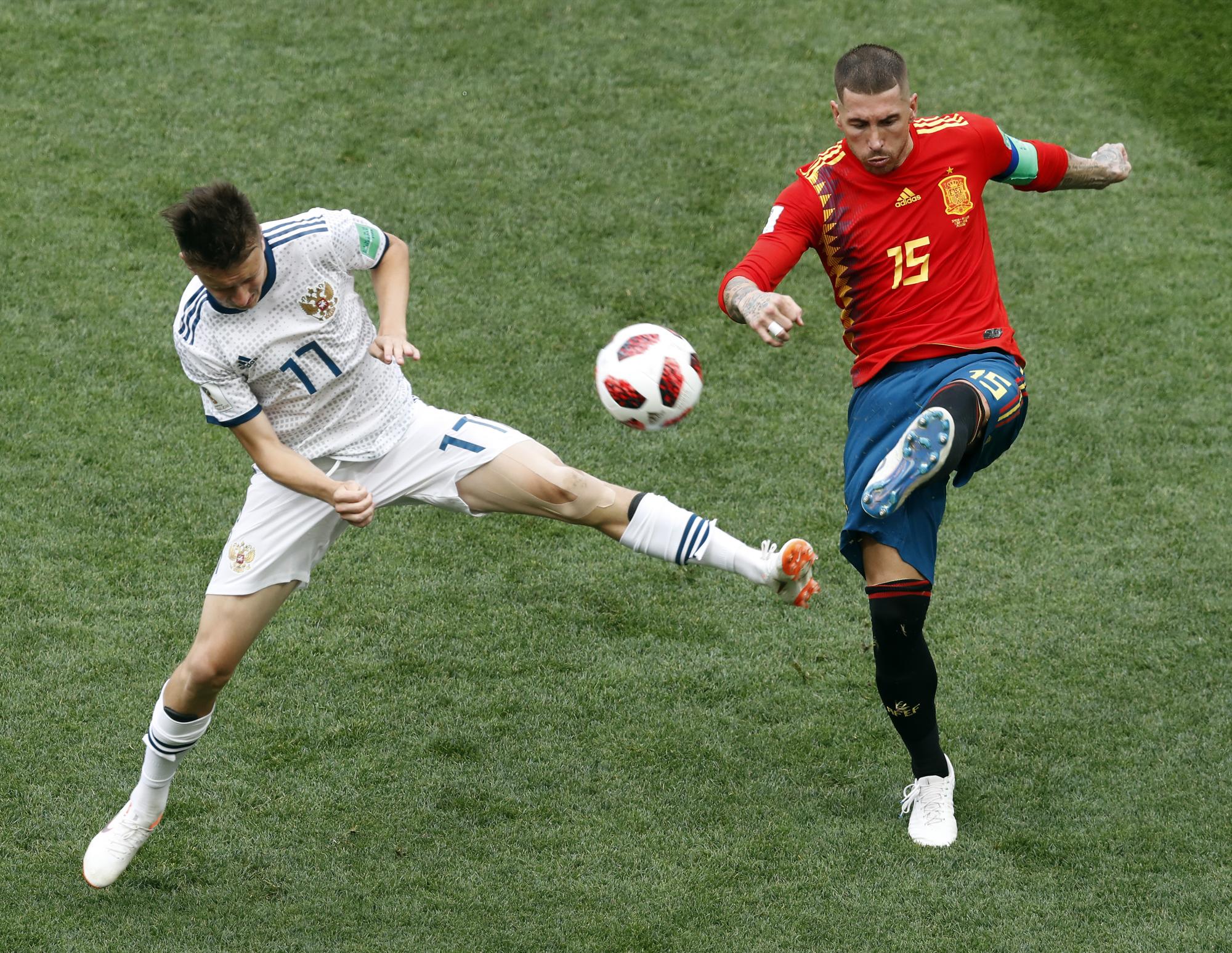 Alexander Golovin de Rusia, izquierda, y Sergio Ramos de España, derecha, pelean por el balón durante la ronda de 16 partidos entre España y Rusia en la Copa Mundial de fútbol 2018 en el Estadio Luzhniki en Moscú, Rusia, domingo 1 de julio de 2018.