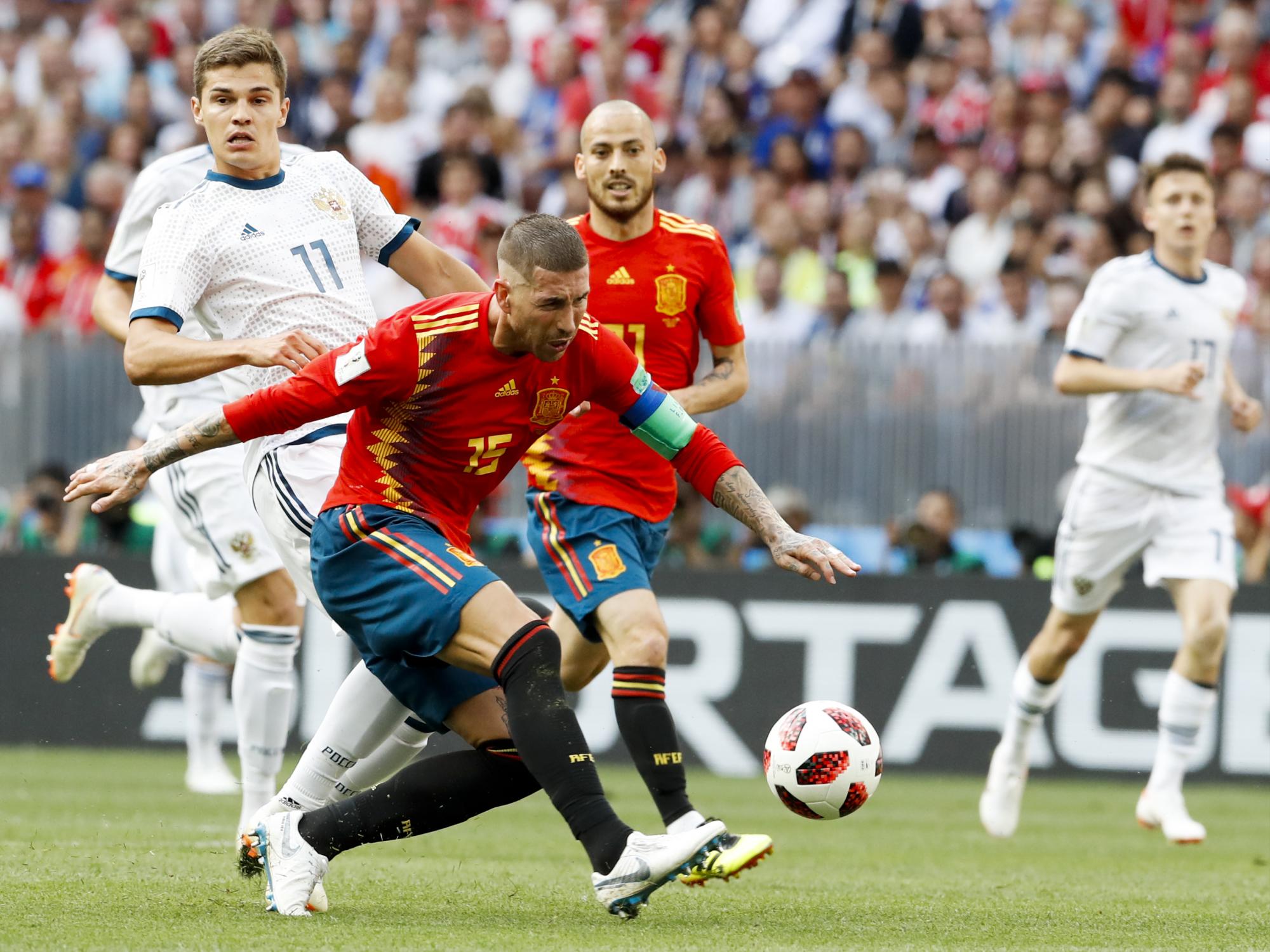 El español Sergio Ramos juega la pelota perseguida por el ruso Roman Zobnin durante su ronda de 16 partidos en la Copa Mundial de fútbol 2018 en el Estadio Luzhniki en Moscú, Rusia, el domingo 1 de julio de 2018.