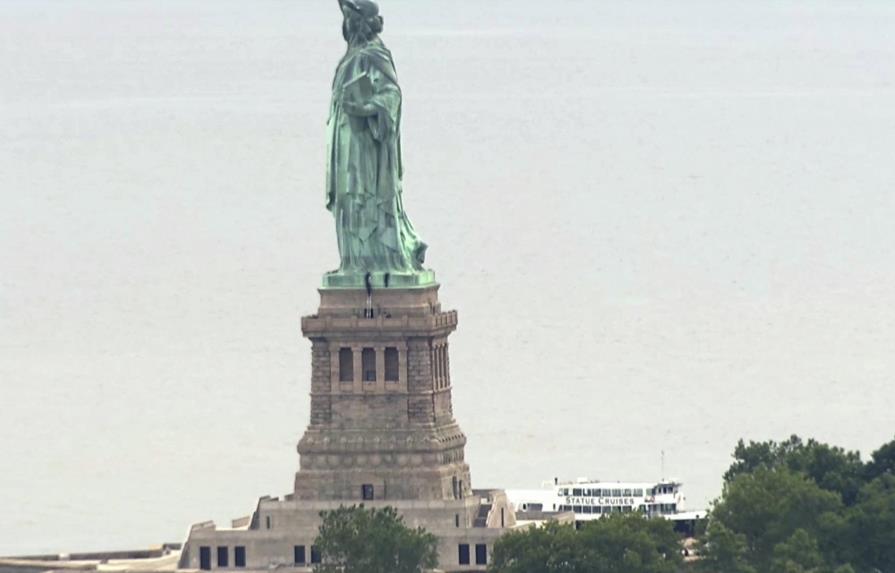 Mujer intenta escalar la base de la Estatua de la Libertad