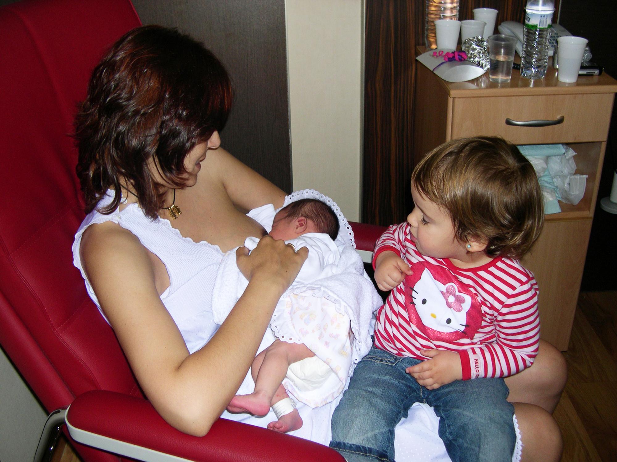 Una madre amamanta a su hija recien nacida junto a su hija mayor. EFE/Joaquín Ruiz