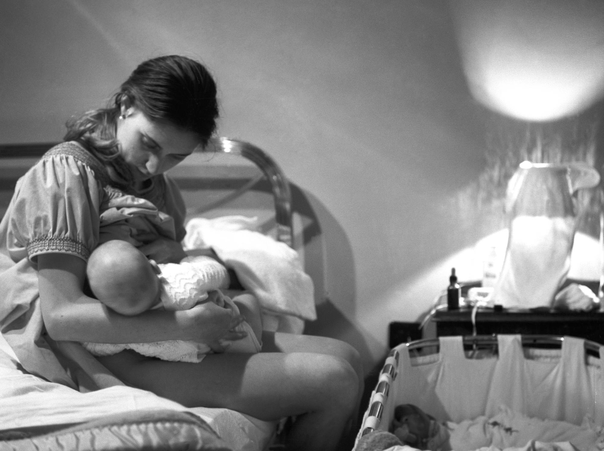 Una mujer amamanta a su hijo durante la noche. EFE