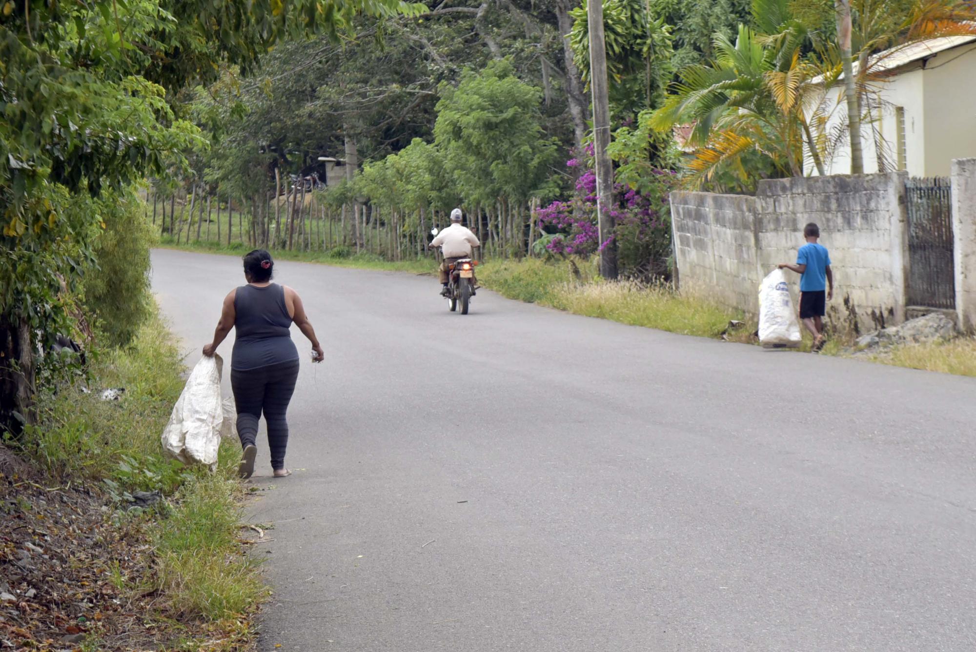 Dos comunitarios recogen basura en Las Placetas.