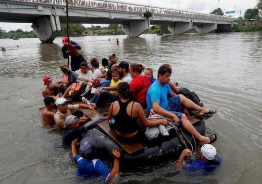 Caravana de migrantes hondureños cruza río que separa Guatemala y México